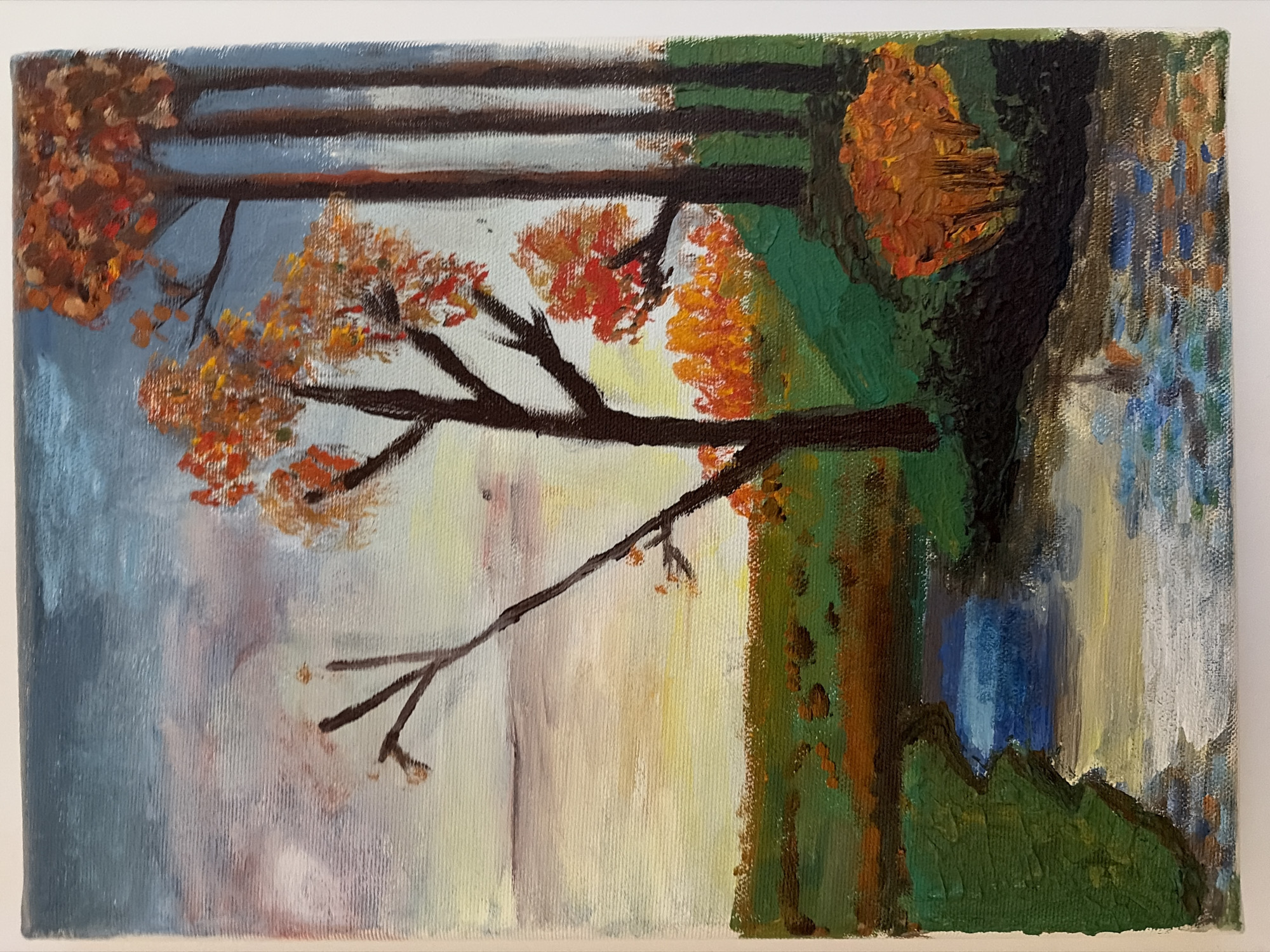 This is a painting of an autumnal landscape with a river. The scene depicts trees with orange and red foliage on the right side of the image, a cluster of trees with bare branches in the center, and a river flowing through a green field. The sky is a mix of blue and muted pinks, suggesting either dawn or dusk. There are no people visible in the painting. The style of the painting is impressionistic, with visible brushstrokes and a focus on color and light. The painting is framed by a white border. The location is not identifiable within the city of Germasogeia Municipality, Cyprus, as the image is a work of art and not a photograph of a specific place.