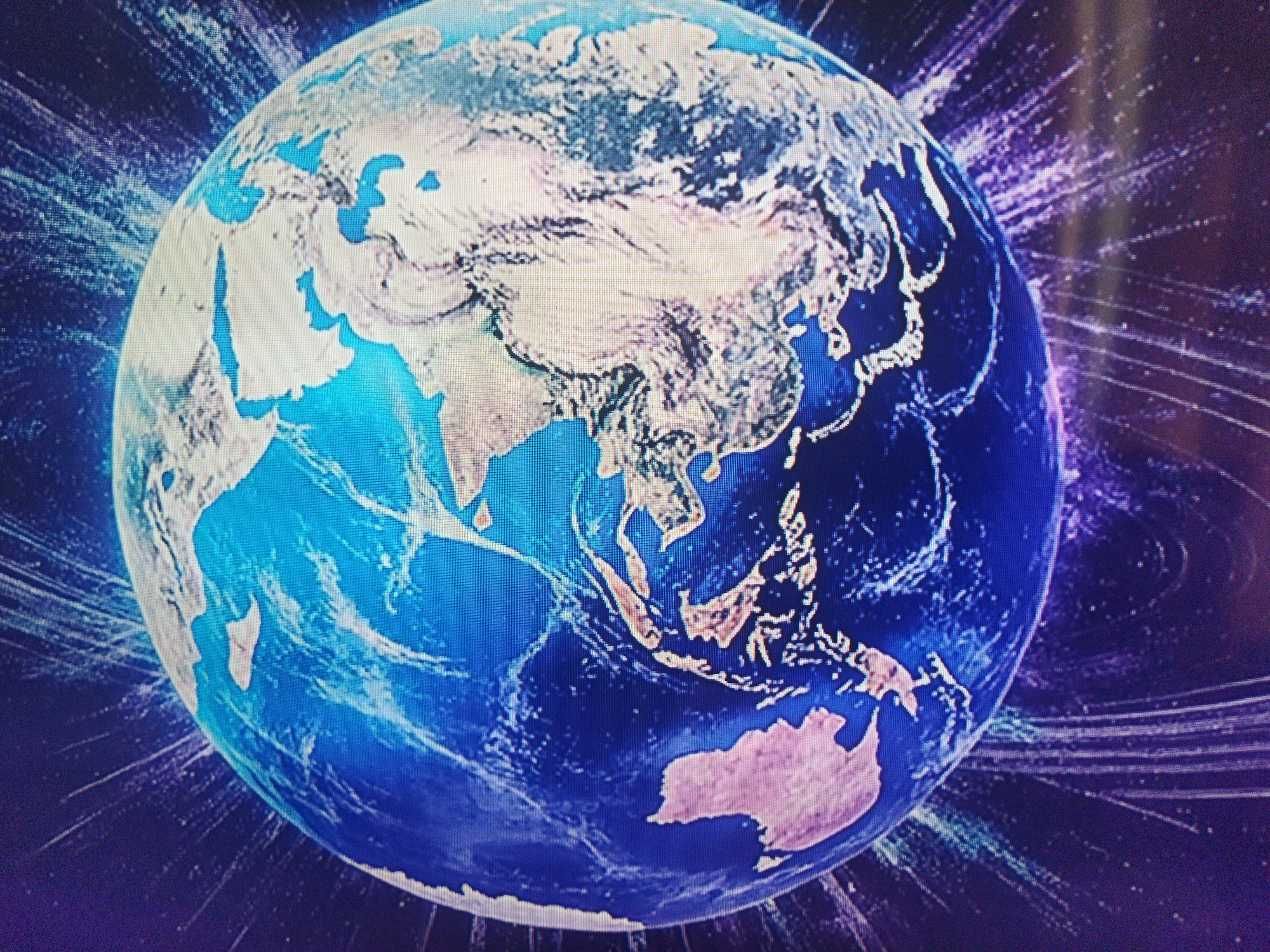 The image shows a stylized representation of the Earth, focusing on the Eastern Hemisphere, with the backdrop of a space-like design featuring radiating lines. Landmasses visible include Asia, Australia, and parts of the Middle East and Africa. The oceans are rendered in various shades of blue. The presence of Ukraine cannot be verified with just this image, and thus it cannot be tied to Kramatorsk.