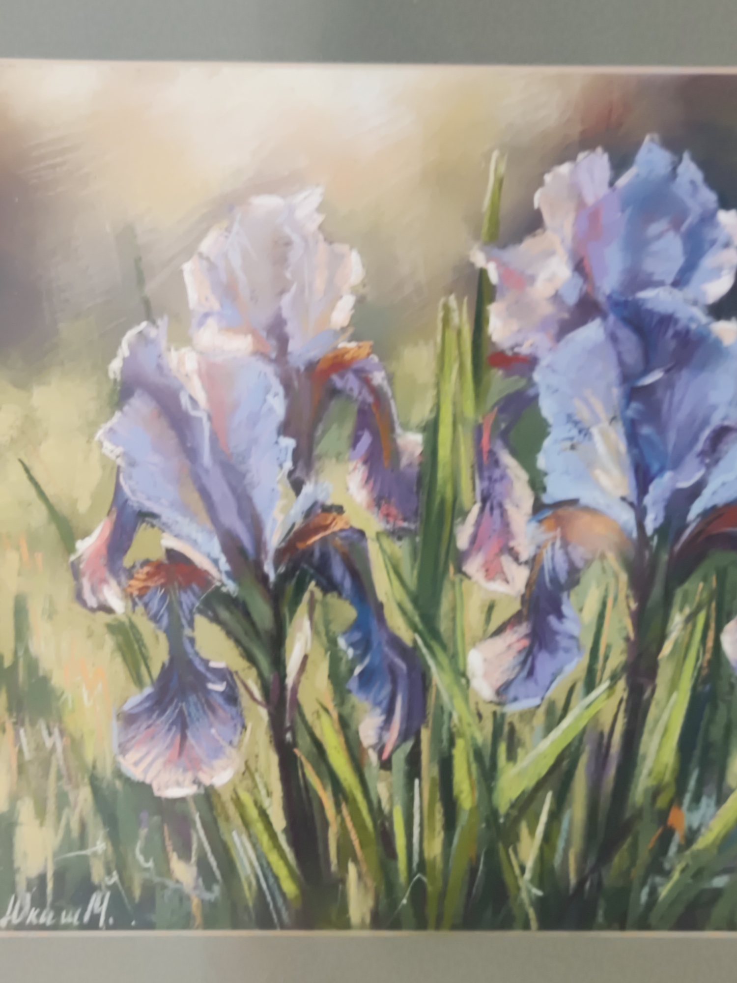 The image is a painting of several purple irises with green stems and leaves. The background is blurred and consists of soft greens and yellows, suggesting an outdoor setting. There is a signature in the bottom left corner of the painting, which appears to read "Ю. Жма м.". This painting is likely located in Bar, Montenegro, as per the prompt.