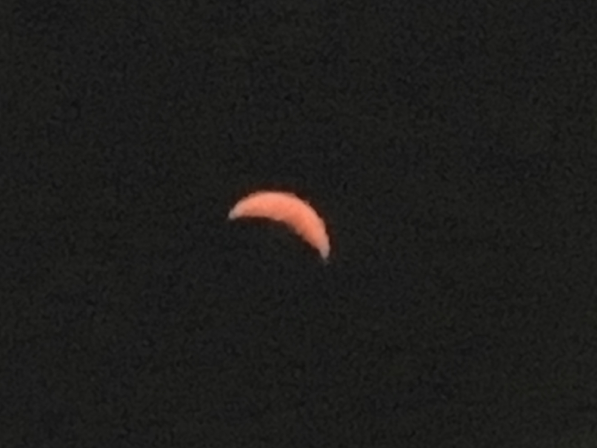 The image shows a crescent moon against a dark, starry sky. The moon is a pale orange color and appears to be illuminated from the right. There are no discernible features of Limenaria, Greece, in this image, as it only depicts the celestial body and the night sky.
