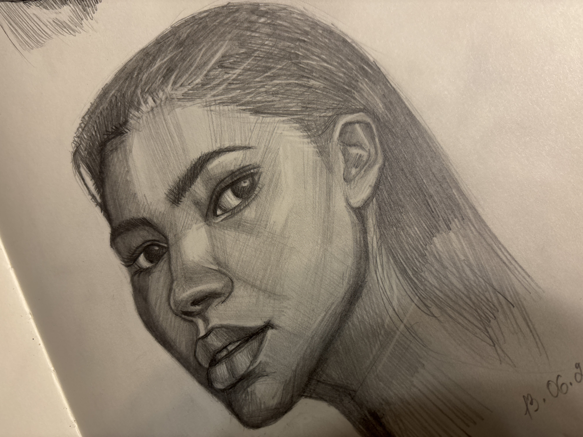 A sketch of a woman's face, turned slightly toward the viewer, is depicted on a white page, presumably in a sketchbook. The drawing is done in pencil, with varying shades of gray suggesting light and shadow. The woman has smooth, straight hair styled back from her forehead, a well-defined eyebrow, a nose with a distinct bridge and nostrils, and full lips that are slightly parted. Details of her eye, including the iris, pupil, and reflected light, are visible. The ear is also rendered in some detail. The overall style of the drawing is realistic, with a focus on capturing the likeness and features of the subject. In the bottom right corner, there is a date written: "13.06.20". The setting and location of the image are not possible to determine from the visual information, so Izhevsk, Russia is irrelevant.