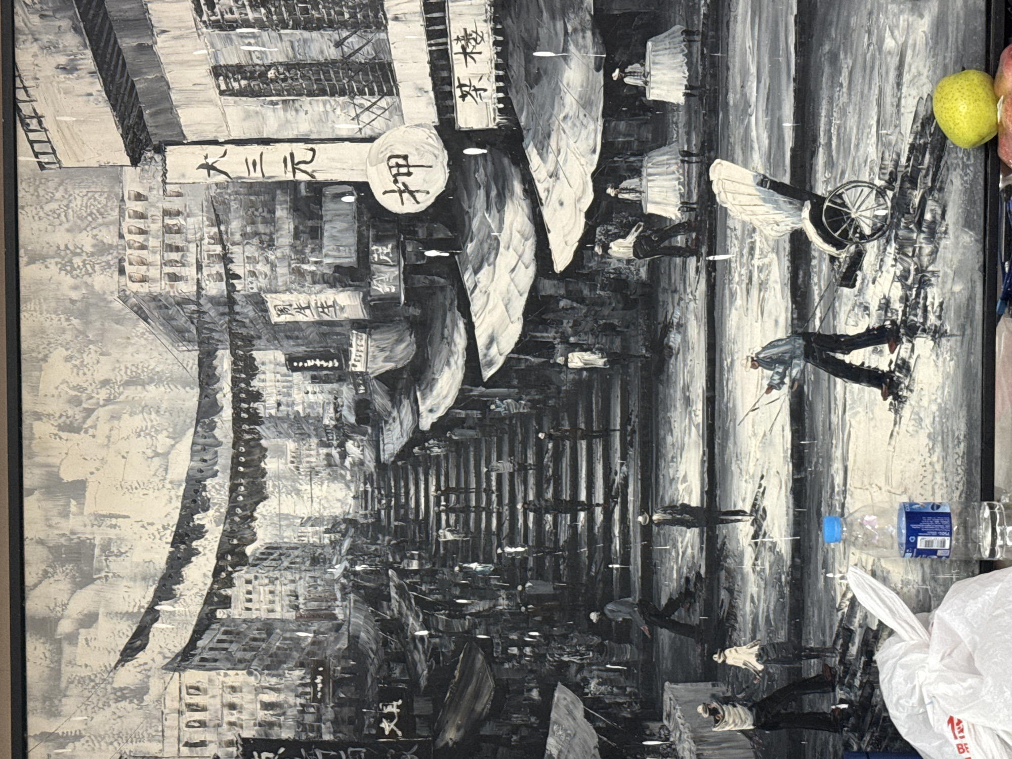 The image is a black and white oil painting depicting a bustling street scene in Hong Kong. The painting captures a steep, stone-paved staircase lined with market stalls and multi-story buildings. Red banners with Chinese characters hang across the street, creating a sense of depth and atmosphere. People are shown walking up and down the stairs, browsing at the stalls, and sitting at tables outside establishments. A rickshaw is visible in the foreground, being pulled by a man. The overall impression is one of a vibrant, lively urban environment.