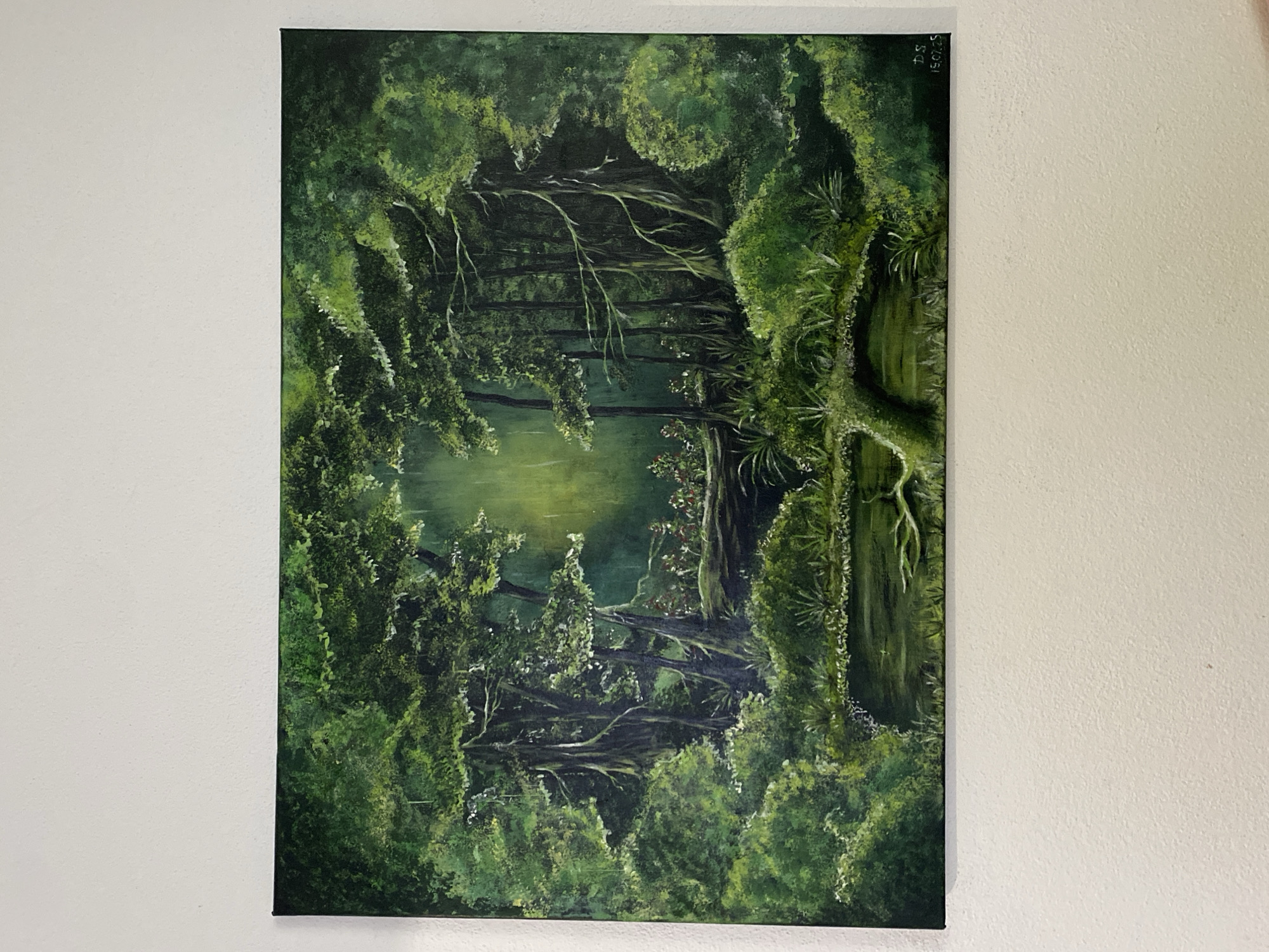 This is an oil painting depicting a dense, lush forest scene, likely a swamp or a very wet woodland, given the reflections in the water. The dominant colors are various shades of green, creating a rich, overgrown, and somewhat mysterious atmosphere.
The painting features a body of water in the center, reflecting the surrounding trees and foliage. Twisted branches and vines hang over the water, some appearing to reach across it, creating a sense of depth and enclosure. The trees are tall and densely packed, with thick canopies that filter the light. The undergrowth is abundant, with ferns and other plants covering the ground. The overall impression is one of wild, untamed nature.
There are no people or animals visible in the painting. The lighting suggests it could be a soft, diffused light, perhaps on an overcast day or deep within the forest where sunlight struggles to penetrate. The scene evokes a feeling of tranquility, solitude, and perhaps a touch of the ethereal.
In the top right corner of the painting, there is some visible text, appearing to be a signature or date. It reads "DS" and "15.02.25". This suggests the painting was created by an artist named DS on February 15, 2025. The location context of Purkersdorf, Austria, implies this might be a representation of a natural landscape found in or inspired by that region.