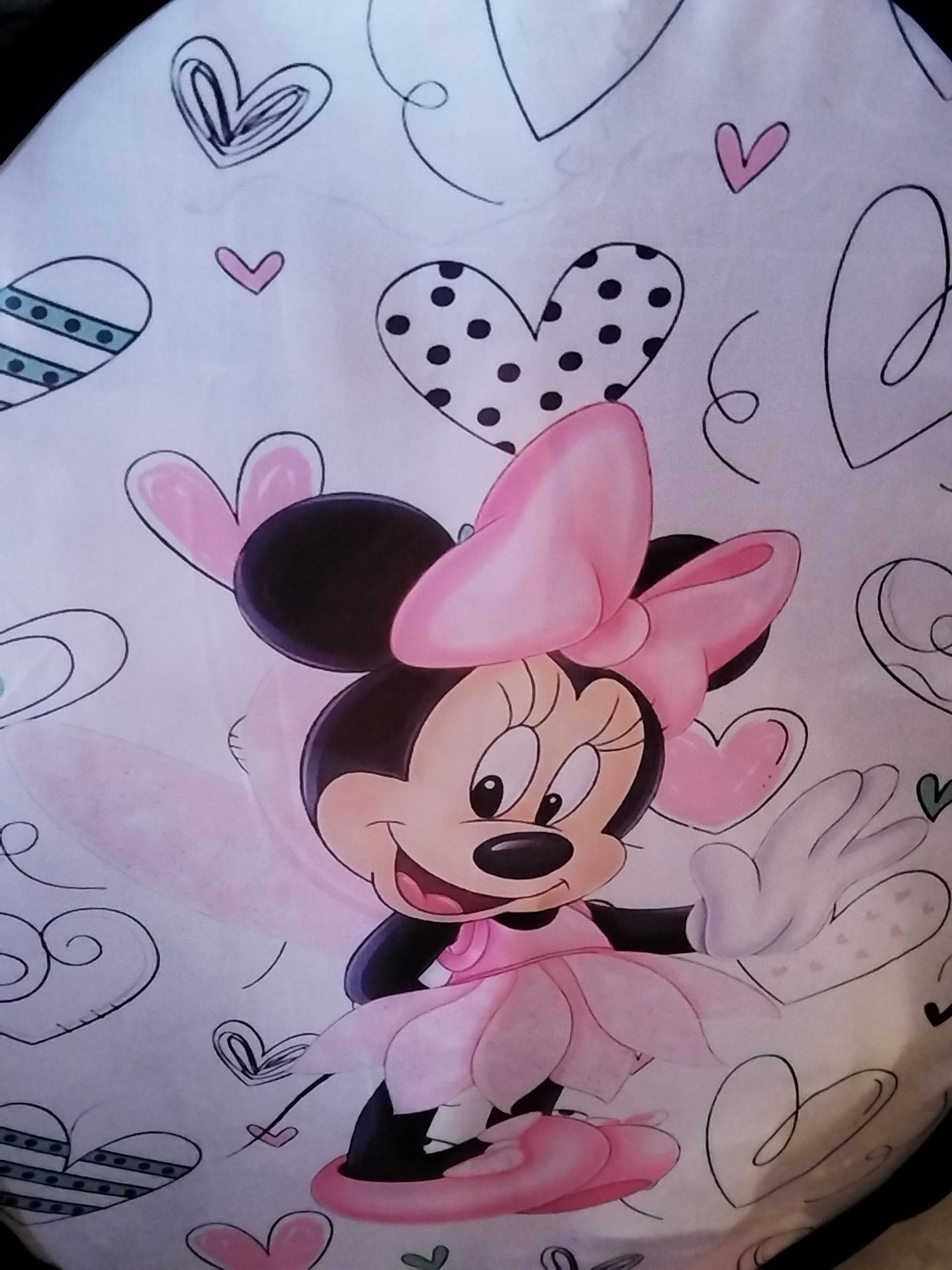 The image shows a drawing of Minnie Mouse in a pink tutu and bow, surrounded by various heart designs. The background is white.