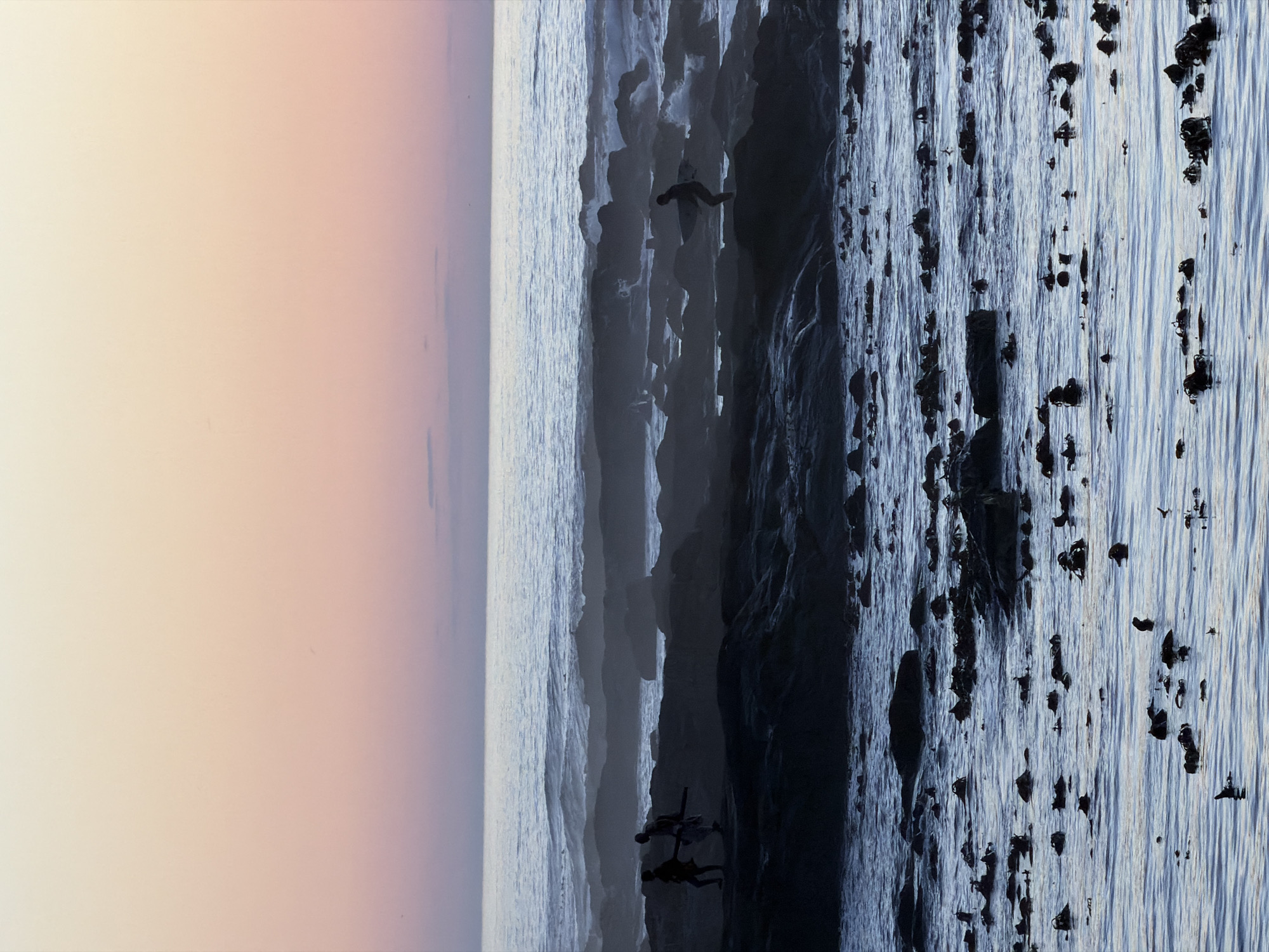 The image shows a vertical panorama of what seems like a rocky beach scene, likely around Cape Town, South Africa, judging by the coastal landscape. On the left, the sky transitions from light peach to light purple near the horizon. Adjacent to this is the sea, appearing as a wide band of greyish-blue. Further right, the coastline features a dramatic, craggy cliff face with dark grey rock formations.
Several small, indistinct human figures are present. A group of two or three can be seen near the base of the cliffs, appearing to be standing or climbing. Another figure, possibly a bird or another person, is further up the cliff.
The foreground consists of the ocean with numerous dark objects, likely rocks or clumps of seaweed, scattered across the surface of the water. The water itself is a textured mix of lighter and darker blues, indicating movement and light reflecting off the ripples.