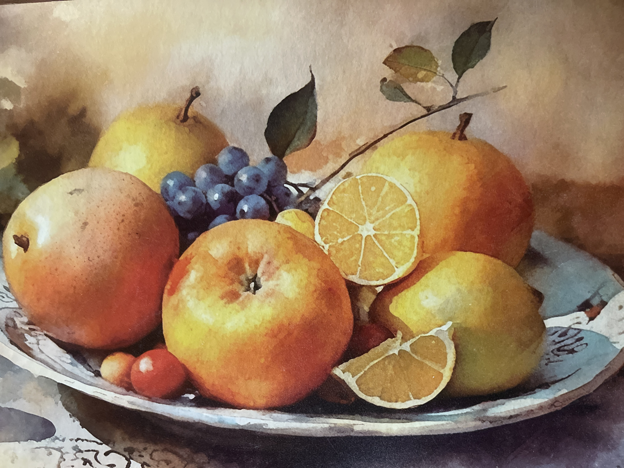 A close-up, overhead, watercolor painting depicts a silver bowl overflowing with various fruits, including a large orange apple, several pears, a bunch of dark blue grapes, two sliced oranges, and some small red berries. The background is a soft, blurred gradient of light brown and cream colors, suggesting a diffused light source. The fruits appear ripe and are arranged in a natural, slightly jumbled manner. The painting has a soft, artistic texture characteristic of watercolor. There are no people or specific environmental features identifiable that would allow for a connection to Minsk, Belarus.