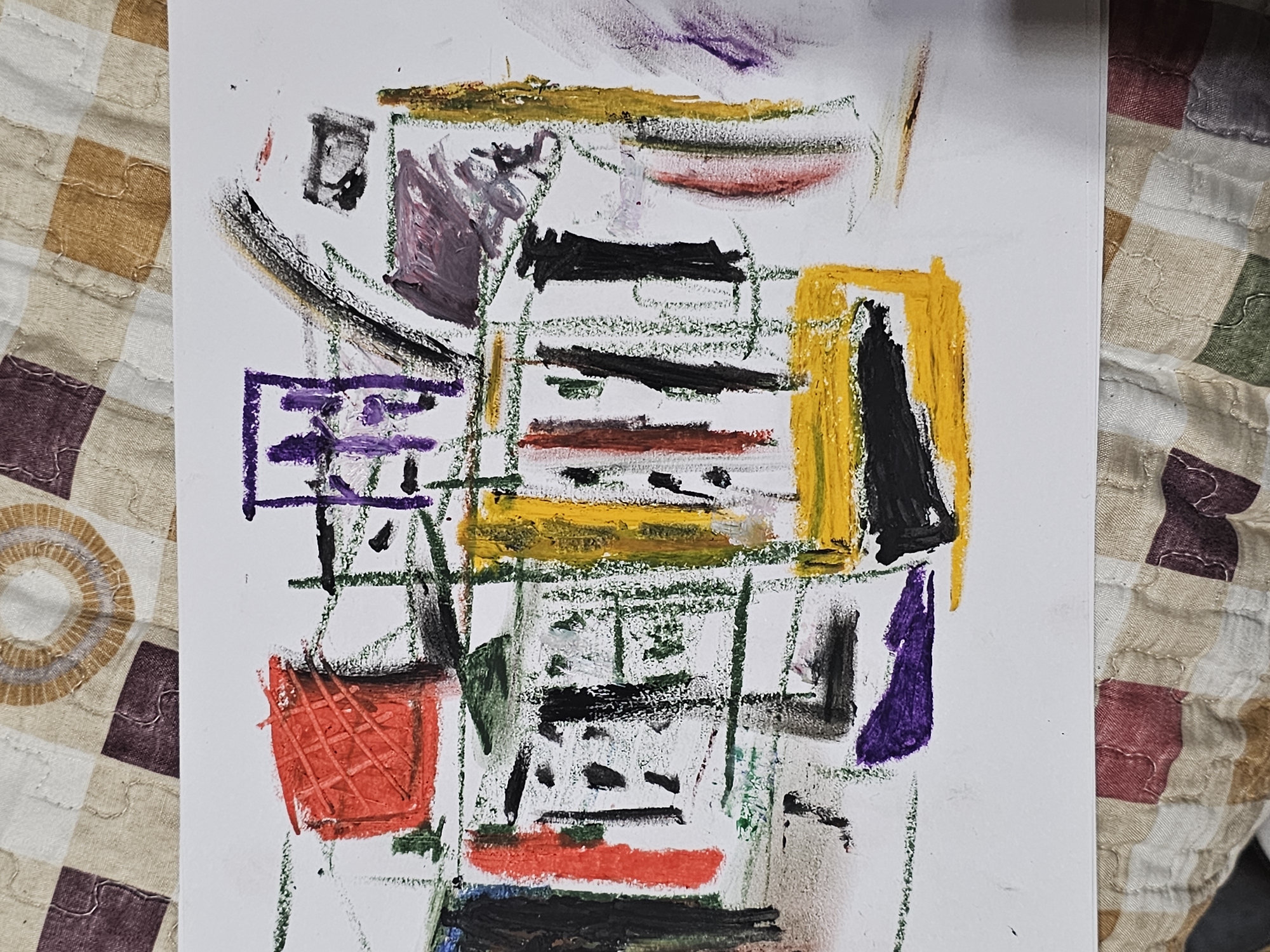 The image shows an abstract painting on a white sheet of paper. The painting consists of a grid-like structure created with green lines, and various shapes and colors are painted within these lines. The colors include red, yellow, purple, black, and green. The painting is placed on a patterned fabric or quilt with squares in various colors, including brown, beige, purple, and green. The painting style is crude. There is no indication of the location of Plovdiv, Bulgaria.
