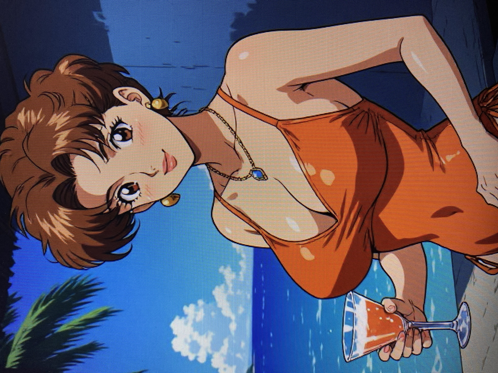 The image depicts an anime-style illustration of a woman in an orange swimsuit holding a cocktail glass. She has brown hair styled in a bouffant, large brown eyes, and is wearing gold hoop earrings and a necklace with a blue pendant. The background suggests a tropical or beach setting with a blue sky, water, clouds, and palm fronds. There is no discernible location in the city of Yerevan, Armenia, within this image.
