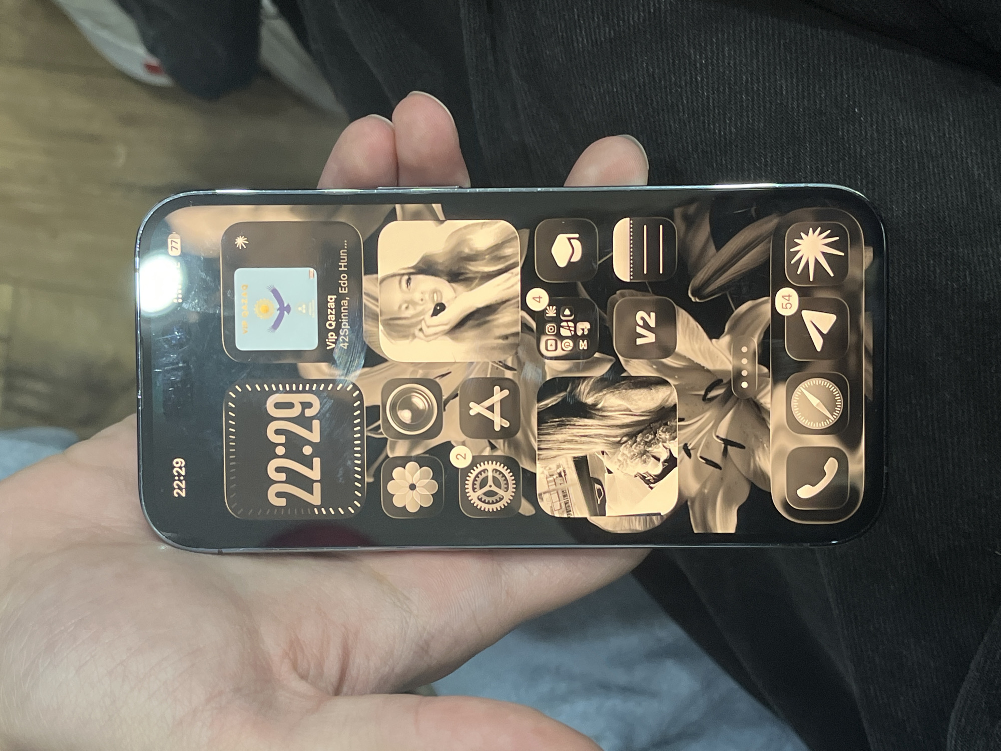 A person holds a smartphone in their hand. The phone's screen displays a home screen with several app icons. Some of the apps appear to be organized into custom widgets. The time displayed on the phone is 22:29. Notifications are present at the top of the screen. The location mentioned in the app name is "Edo Hun..." which is likely referring to the Edo-Hun region. The scene doesn't provide enough information to pinpoint the exact location within the city of Unknown, Unknown.