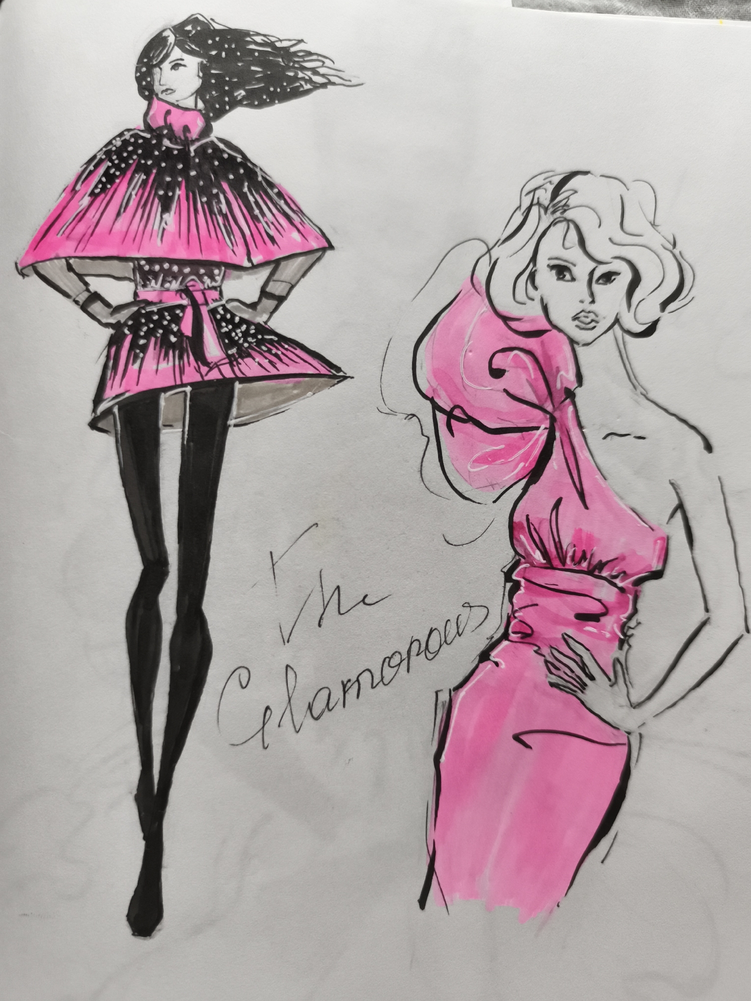 This is a fashion illustration of two models wearing pink and black outfits. The model on the left is wearing a short, caped dress with a high collar and a belted waist. The dress is black with pink accents and white dots. She is also wearing black tights and black shoes. Her hair is dark and styled to appear windblown. The model on the right is wearing a voluminous pink dress with a large bow detail over one shoulder. The dress is off-the-shoulder and gathered at the waist. She has blonde, curly hair and her hands are placed on her waist and chest. The word "the" and "Glamorous" are written in cursive script between the two models. The background is plain white. There is no indication of a specific location within the city of Saint-Denis, France.