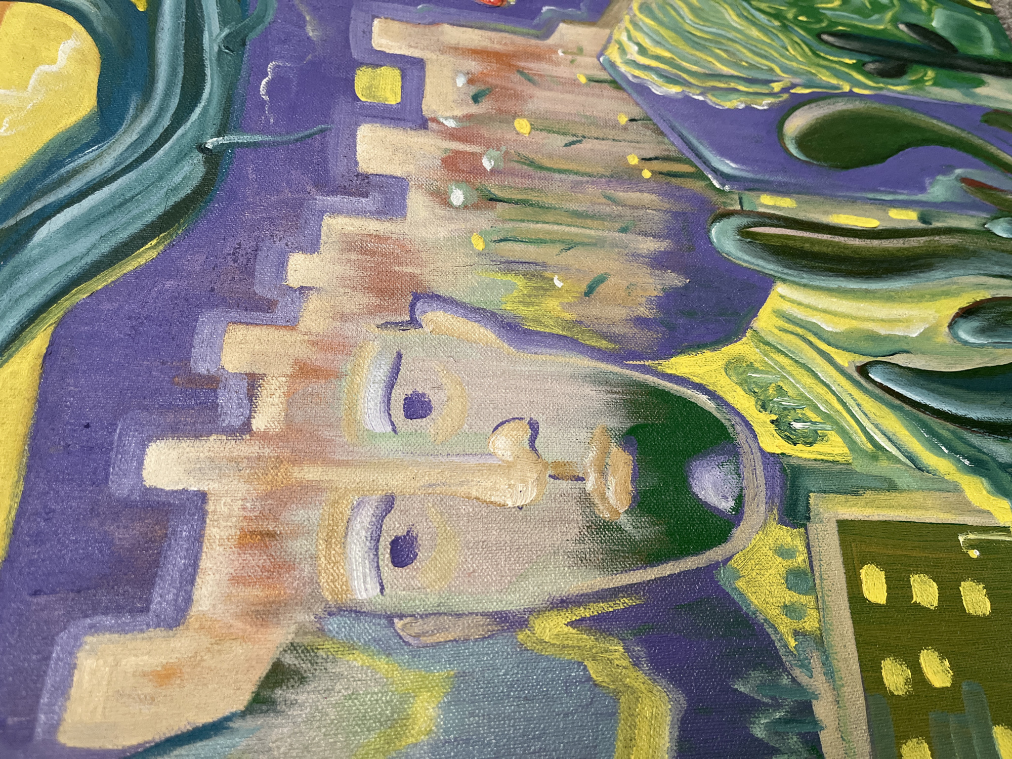 This is a close-up, detail shot of an oil painting. The painting depicts a stylized, abstract portrait of a man in the foreground, with a surreal city landscape in the background. The man's face is rendered in broad strokes of beige and light brown, with large, dark purple eyes and a short, green beard. He wears a headdress that resembles battlements or a crown. Behind him, the city is represented by blocky structures in shades of purple and beige, with yellow squares suggesting windows. There are hints of flora, like small yellow flowers and green stalks, amidst the urban forms. The overall color palette is dominated by purples, yellows, and greens, with some beige and hints of red. The painting has a textured appearance due to the visible brushstrokes on the canvas. There is no indication of the city of Krasnoyarsk, Russia in this artwork.