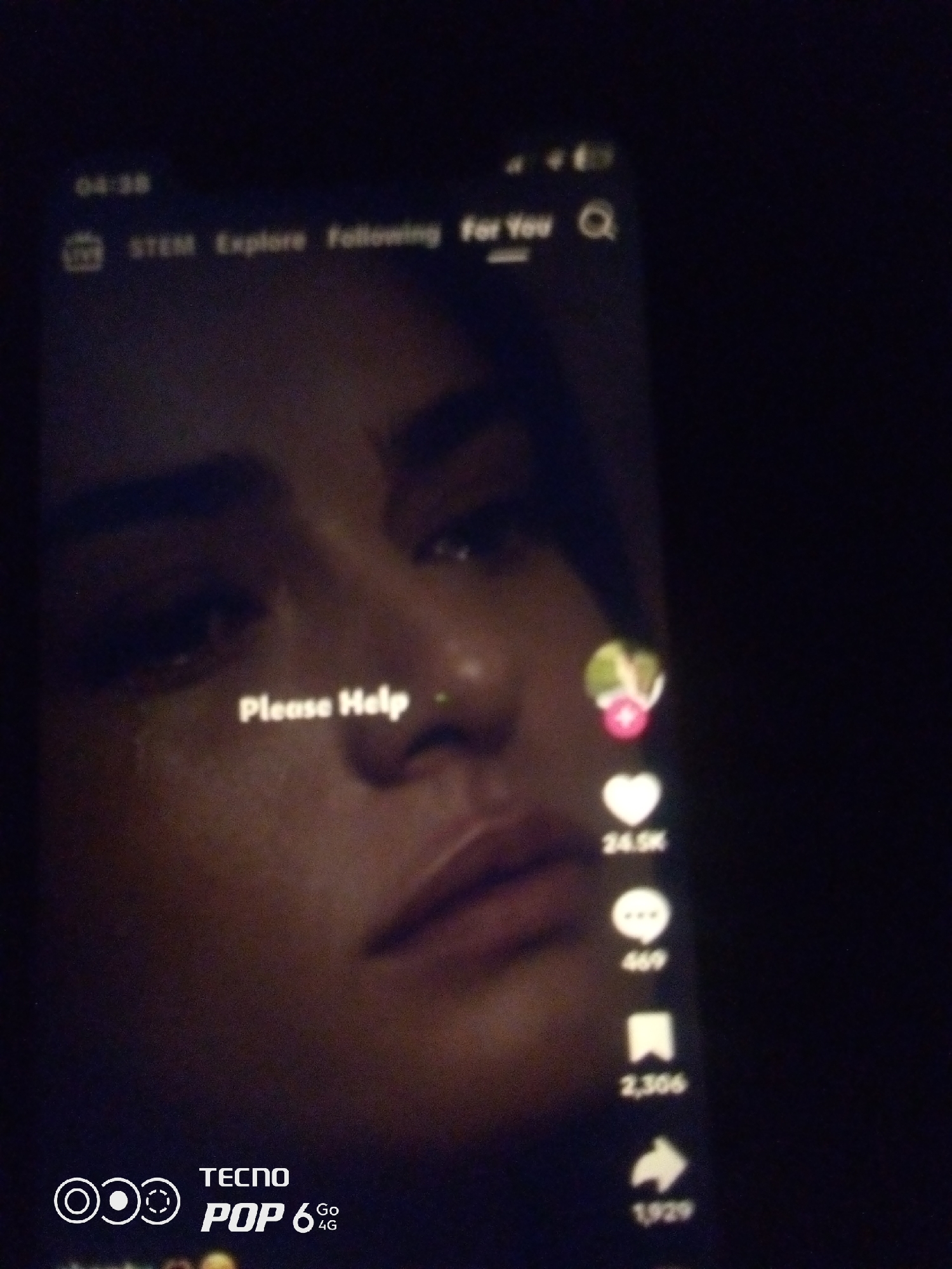 The image shows a close-up of a smartphone screen displaying a video. The video features a woman's face, with text overlaid that reads "Please Help." On the right side of the screen, there are icons for likes, comments, shares, and saves, with corresponding numbers indicating engagement. In the top left corner, the time "04:38" is visible, along with navigation options like "STEM," "Explore," and "Following." At the bottom of the screen, a watermark indicates "TECNO POP 6 GO 4G." The overall scene is dark, suggesting the photo was taken in low-light conditions. There is no information in the image that places the scene in Howayi, Nigeria.