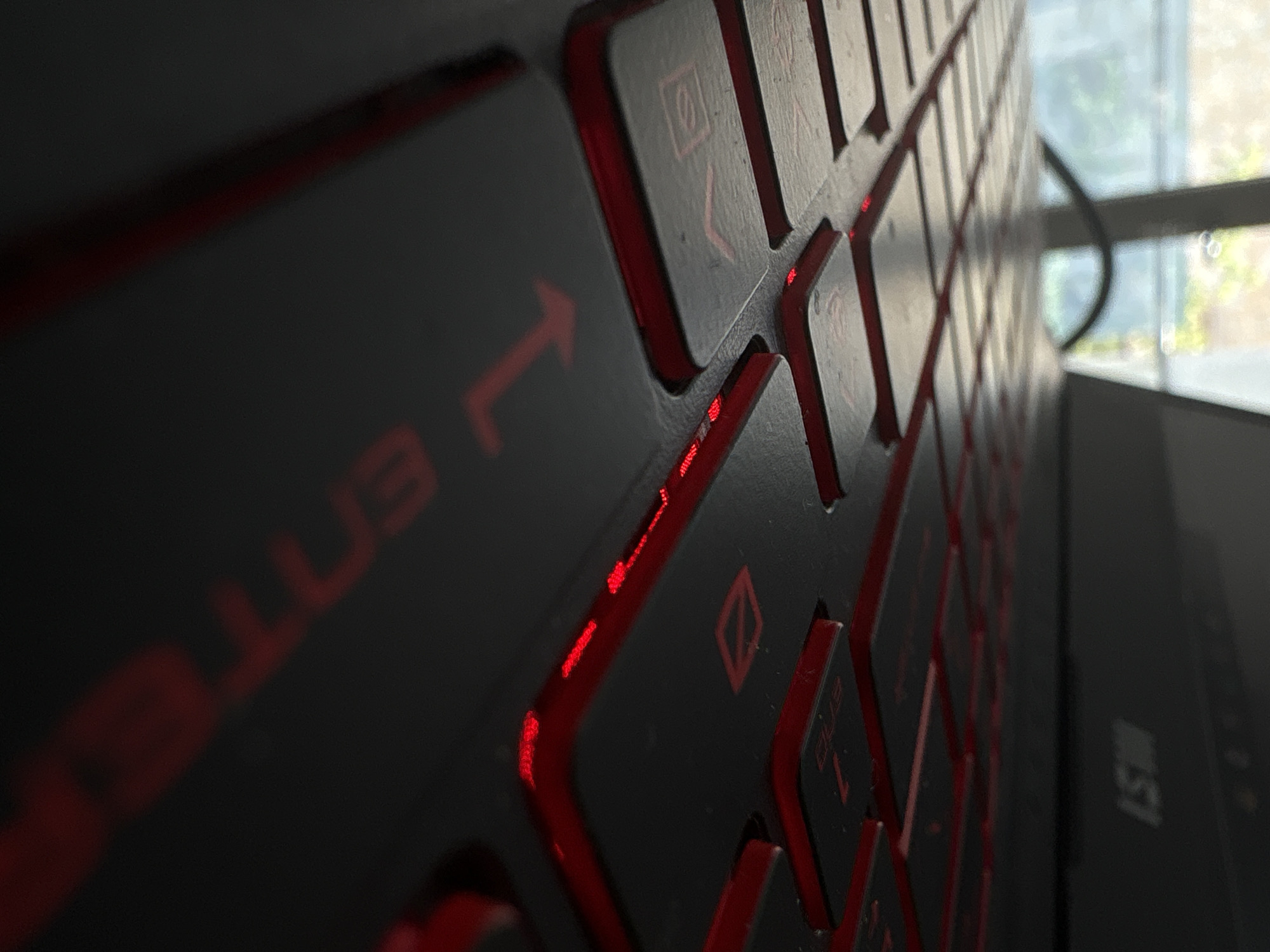 The image shows a close-up view of a laptop keyboard with red backlighting. The keys are dark gray or black. The focus is on the left side of the keyboard, showing the "Enter" key and other keys to its right. The "MSI" logo is faintly visible on the right side of the laptop. A window is partially visible in the background, showing blurry greenery. The image does not contain sufficient information to place it in Yerevan, Armenia.