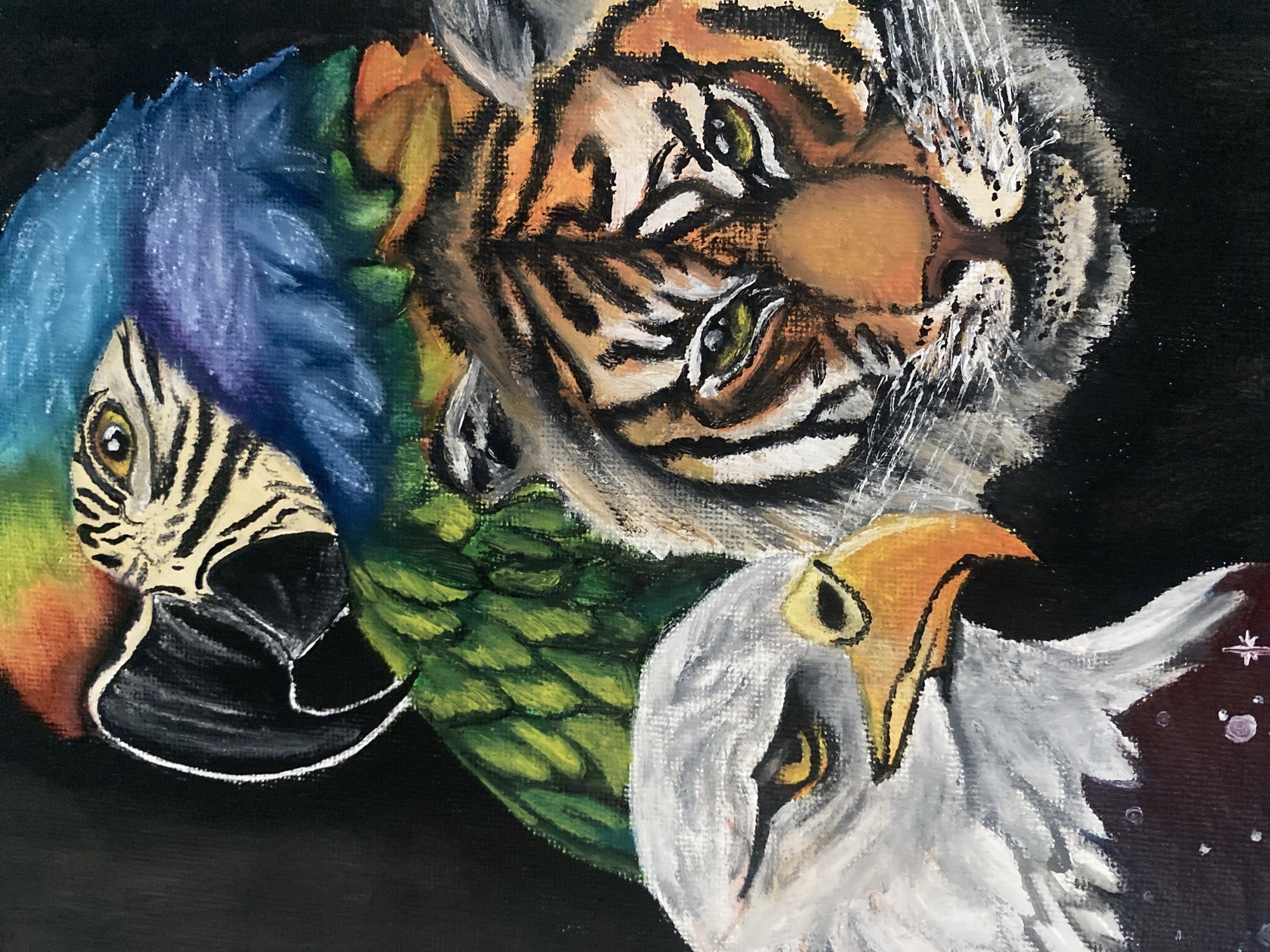 The image is an artwork that depicts the heads of three animals layered on top of each other against a dark background. The topmost animal appears to be a tiger with orange and black stripes. Below the tiger is a parrot, notable for its blue, green, and yellow plumage and its distinctive black beak. The bottom animal is an eagle, recognizable by its white feathers and yellow beak. The setting or the location in Tinaquillo, Venezuela, is not visible.