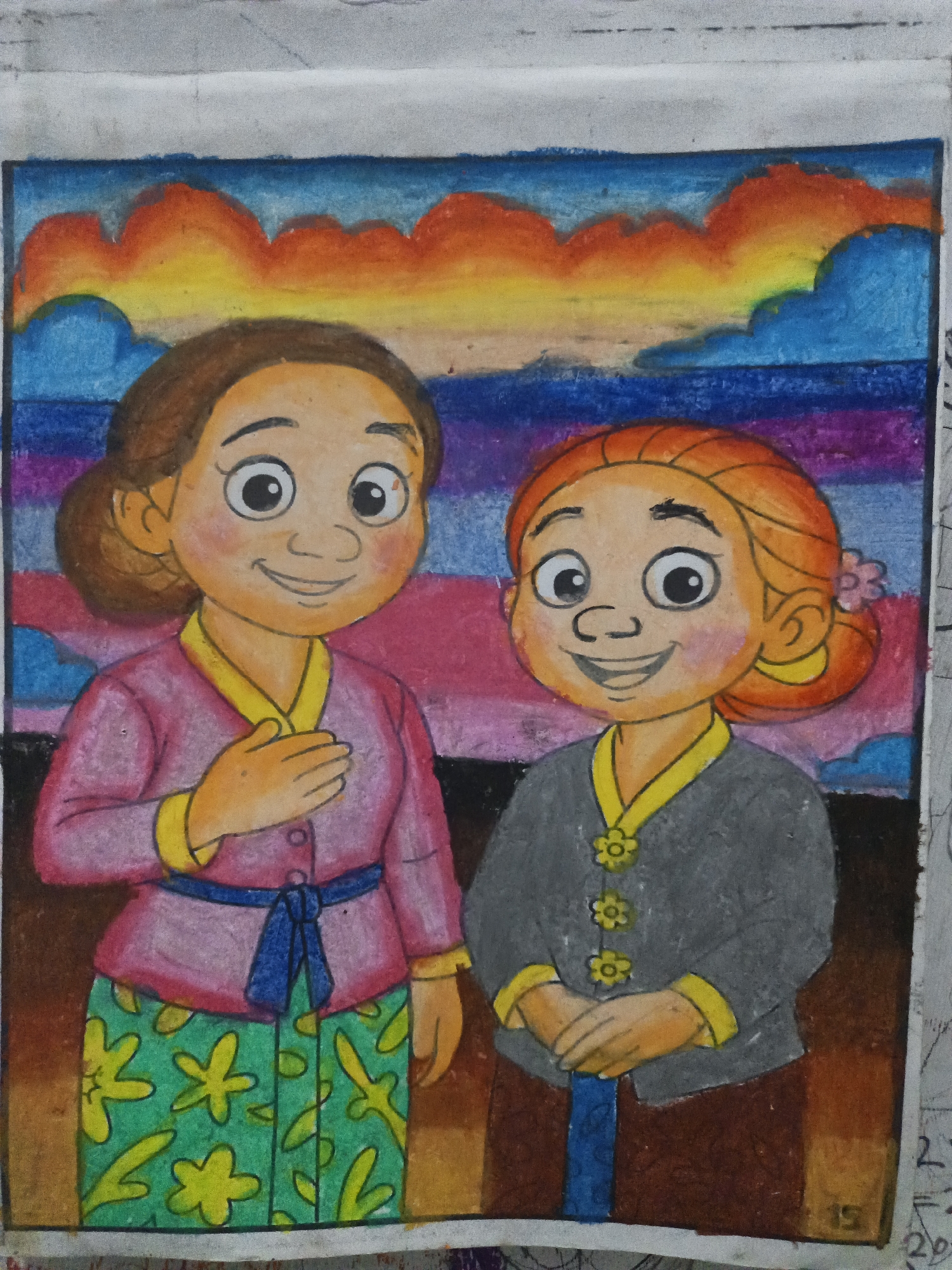 This is a colored drawing of two women in traditional Indonesian attire standing against a colorful sunset sky. The woman on the left has brown hair pulled back in a bun and is wearing a pink top with yellow trim and a blue sash, paired with a green patterned skirt. Her right hand is placed over her chest. The woman on the right has reddish-orange hair styled in a bun with a flower, and is wearing a gray top with yellow trim and floral buttons, also with a blue sash. Her hands are clasped in front of her. The background depicts a gradient of colors representing a sunset, with shades of blue, purple, pink, orange, and yellow. The drawing appears to be done with colored pencils or crayons. The location is specified as Kepulungan, Indonesia.