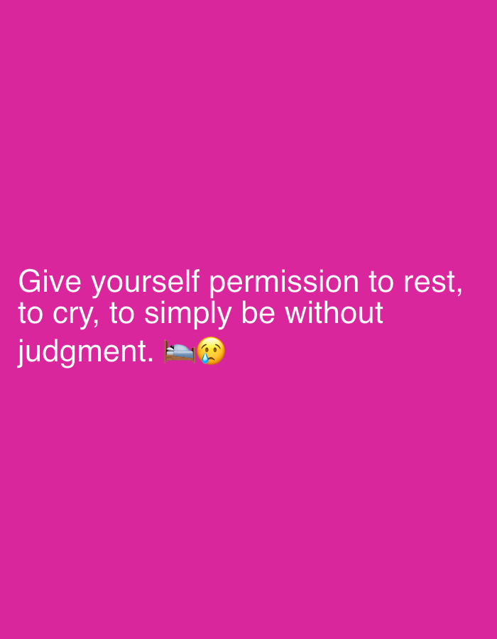 The image is a pink graphic with white text. The text reads: "Give yourself permission to rest, to cry, to simply be without judgment." Next to the word "judgment" are two emojis: a bed with a person under the covers and a sad, crying face. The overall tone of the image is one of self-compassion and permission to feel emotions. There are no people, objects, or scene details visible beyond the text and emojis. The setting is a plain pink background, suggesting a digital graphic rather than a real-world photo. No time of day, weather, or specific location cues are provided.