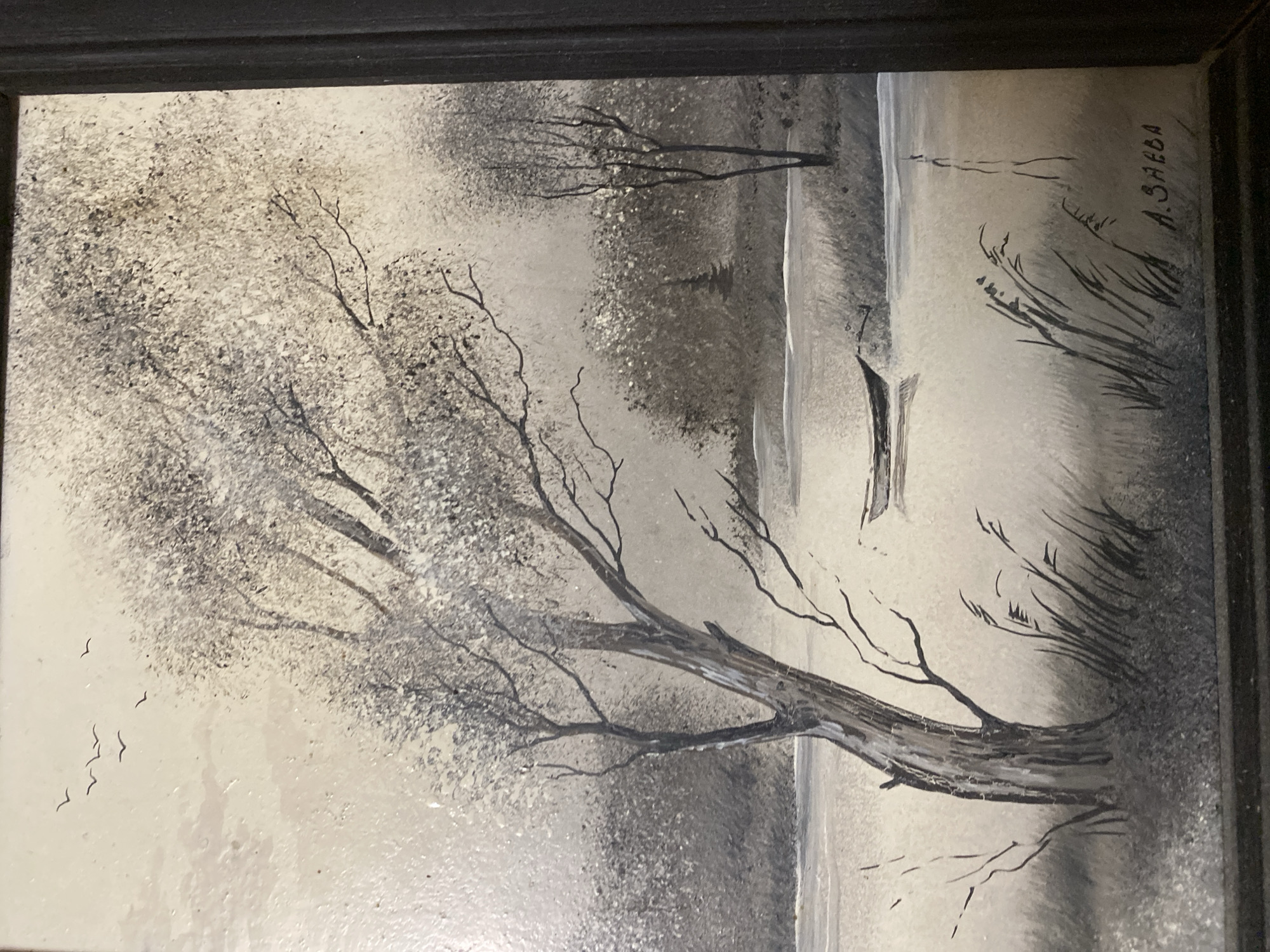 This is a painting, likely oil on canvas, framed in black. The painting depicts a somber winter landscape in grayscale. In the foreground, a large, bare tree with intricate branches dominates the left side of the frame. Its trunk is thick and gnarled, showing textured bark. To the left of the tree, a small flock of birds is flying. The middle ground features a body of water, possibly a lake or river, with a small, dark boat docked near the shore. The far bank is lined with tall, thin reeds or grasses. In the background, more bare trees and a hazy, diffused light suggest a cloudy or foggy atmosphere. The overall mood is quiet and melancholic, evoking a sense of stillness and the harshness of winter. The time of day appears to be overcast, with no direct sunlight. The location context is Novaya Usman', Russia. The signature "A. SAEBA" is visible in the upper right portion of the painting.