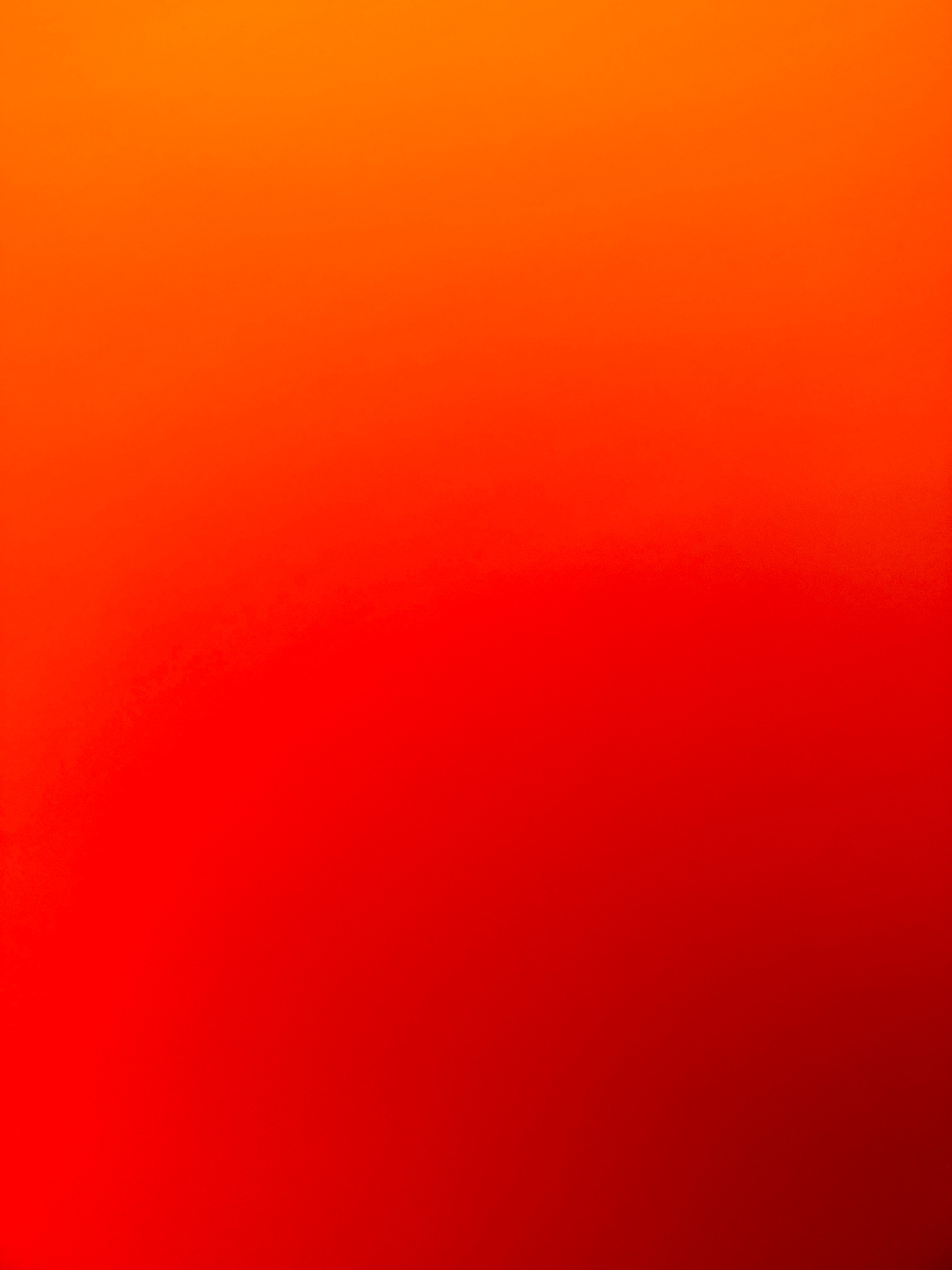The image displays a smooth gradient of colors, transitioning from a bright orange at the top to a deep red at the bottom. There are no discernable objects, people, or any details indicative of a specific location, including Zavolzhye, Russia. The image is purely abstract, characterized by its color gradation.