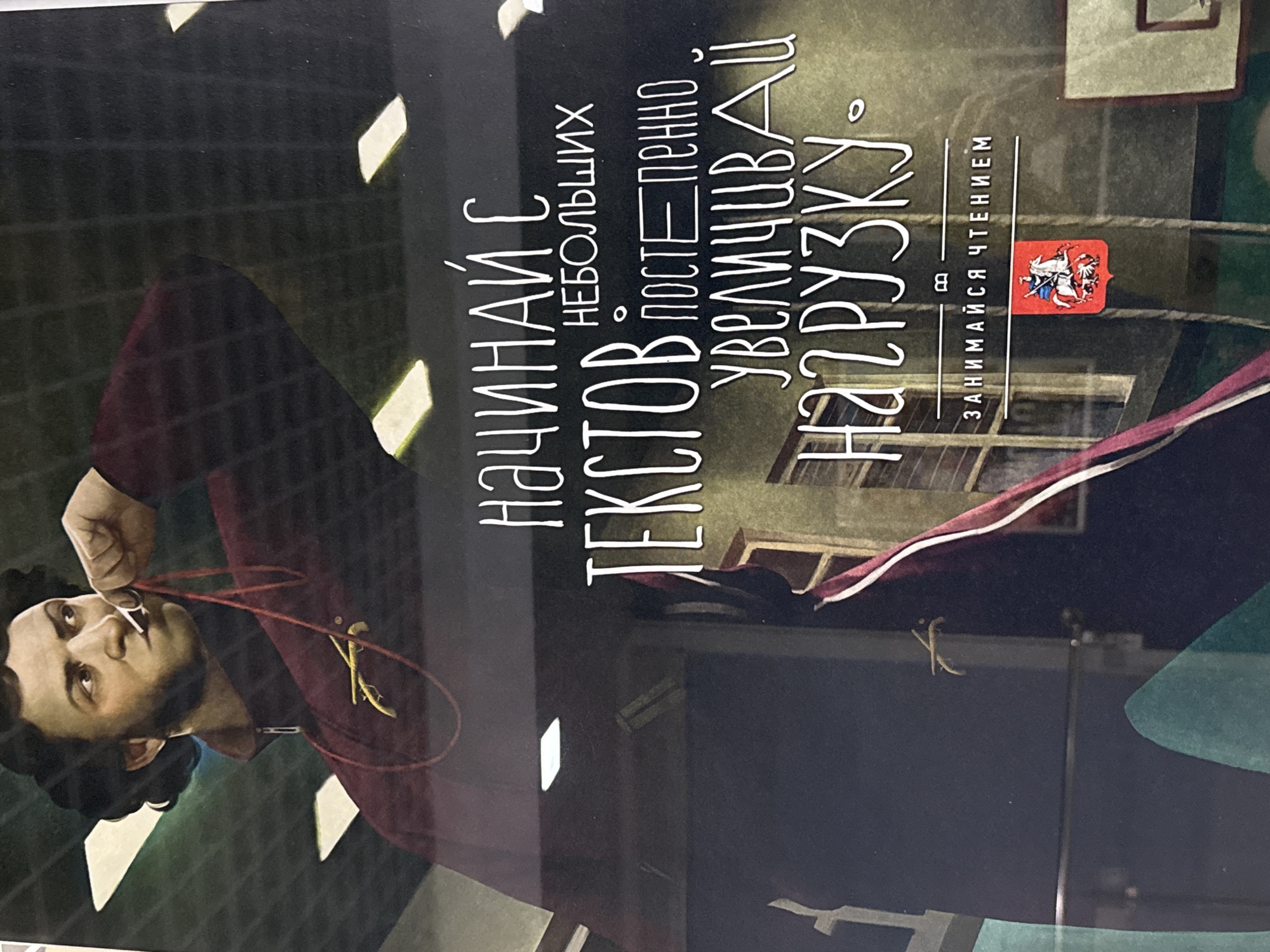The image is a close-up of a book cover or poster featuring an illustration of a man with dark curly hair and a beard, wearing a maroon jacket. He is holding a whistle on a red string to his mouth. The text on the image, written in white Russian letters, reads: "НАЧИНАЙ С ТЕКСТОВ НЕБОЛЬШИХ ПОСТЕПЕННО УВЕЛИЧИВАЙ НАГРУЗКУ. ЗАНИМАЙСЯ ЧТЕНИЕМ." This translates to: "START WITH SMALL TEXTS GRADUALLY INCREASE THE LOAD. ENGAGE IN READING." Below the text, there is a small red emblem with a depiction of a knight on horseback. The background appears to be an indoor sports facility with visible ceiling lights and what looks like a basketball hoop. There is no discernible information in the image or its crops that indicates the location being Votkinsk, Russia.