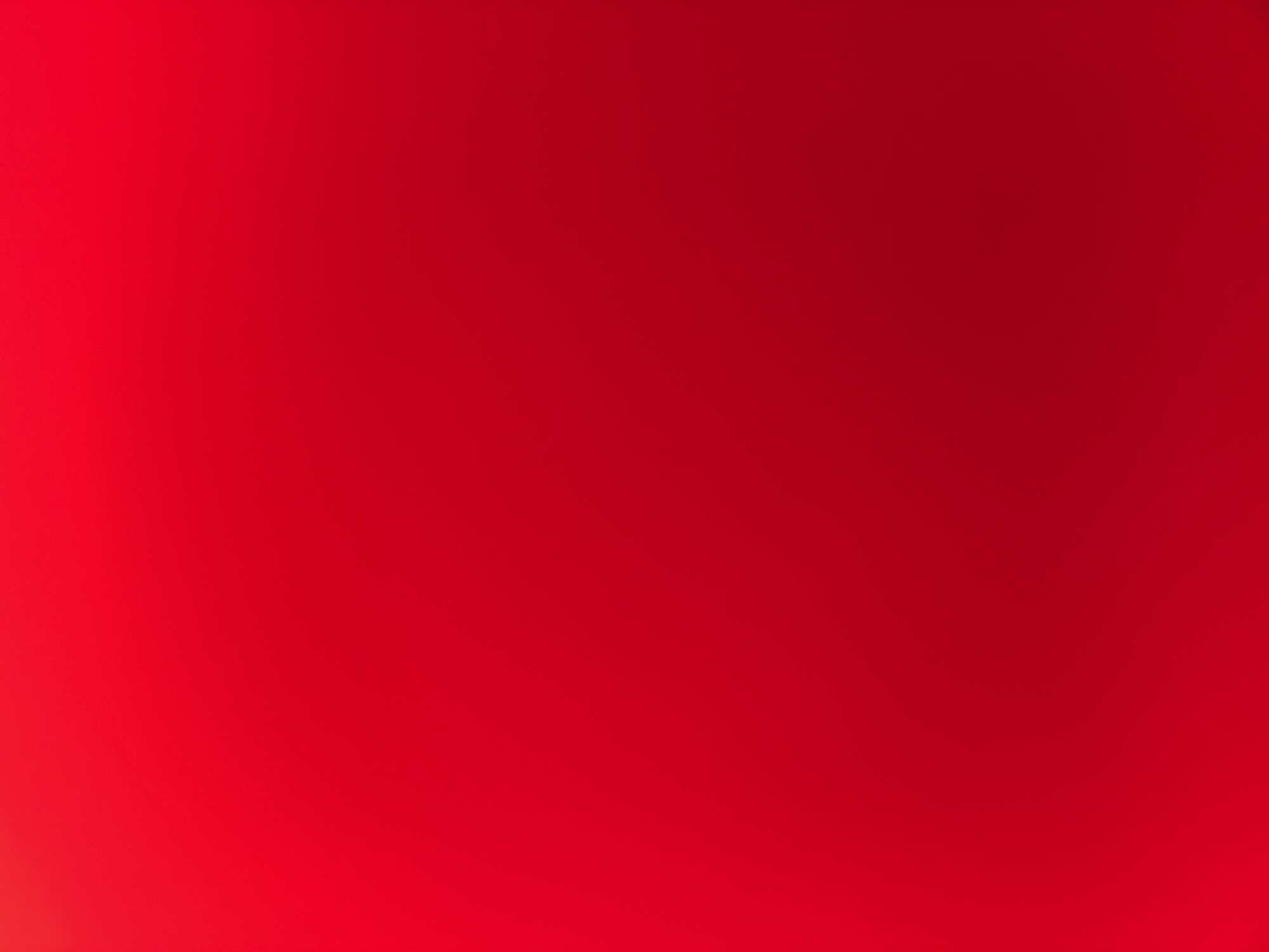 The image is a plain, solid red background with a subtle gradient, lighter on the left side and darker on the right. There are no discernible objects, people, or actions. The image provides no information about its location in Delmenhorst, Germany, or any other specific geographic context.