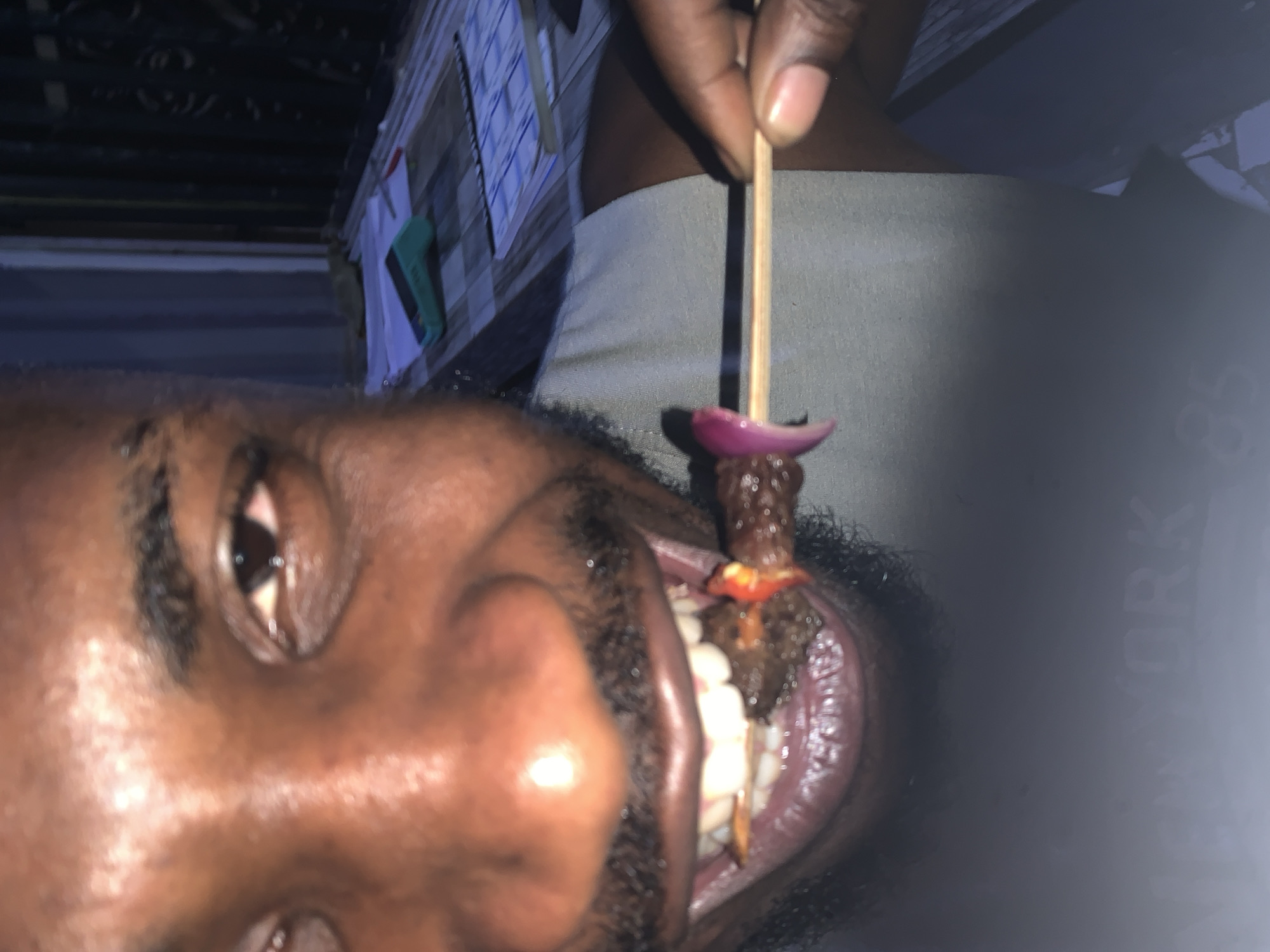 A man is eating a kebab. The location is not discernible from the image.