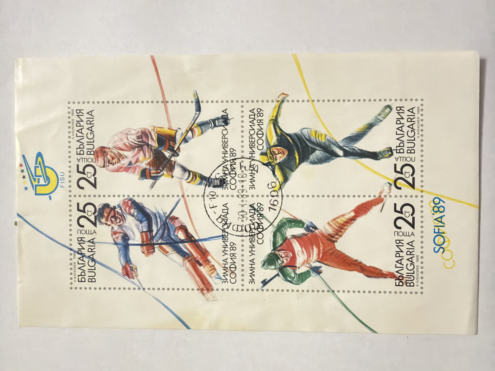 The image shows a block of four Bulgarian postage stamps, commemorating the 1989 Winter Universiade in Sofia. Each stamp features a different illustration of winter sports athletes and incorporates the Bulgarian text "БЪЛГАРИЯ BULGARIA," the denomination "25" and "ПОЩА," the event name "ЗИМНА УНИВЕРСИАДА СОФИЯ'89," and the designer's name "Х. АЛЕКСИЕВ 1988." A circular stamp with the date and inscription "30 - 1.89-40" is applied over the center of the block of stamps. The word "CO SOFIA '89" is printed on the far right. The location of the scene is not depicted in the image.