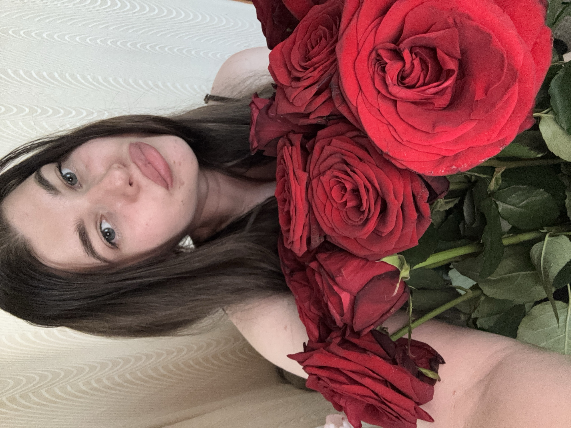 A woman is holding a bouquet of red roses. The image is a selfie-style shot. The location cannot be determined as Мещёры, Russia from the image.