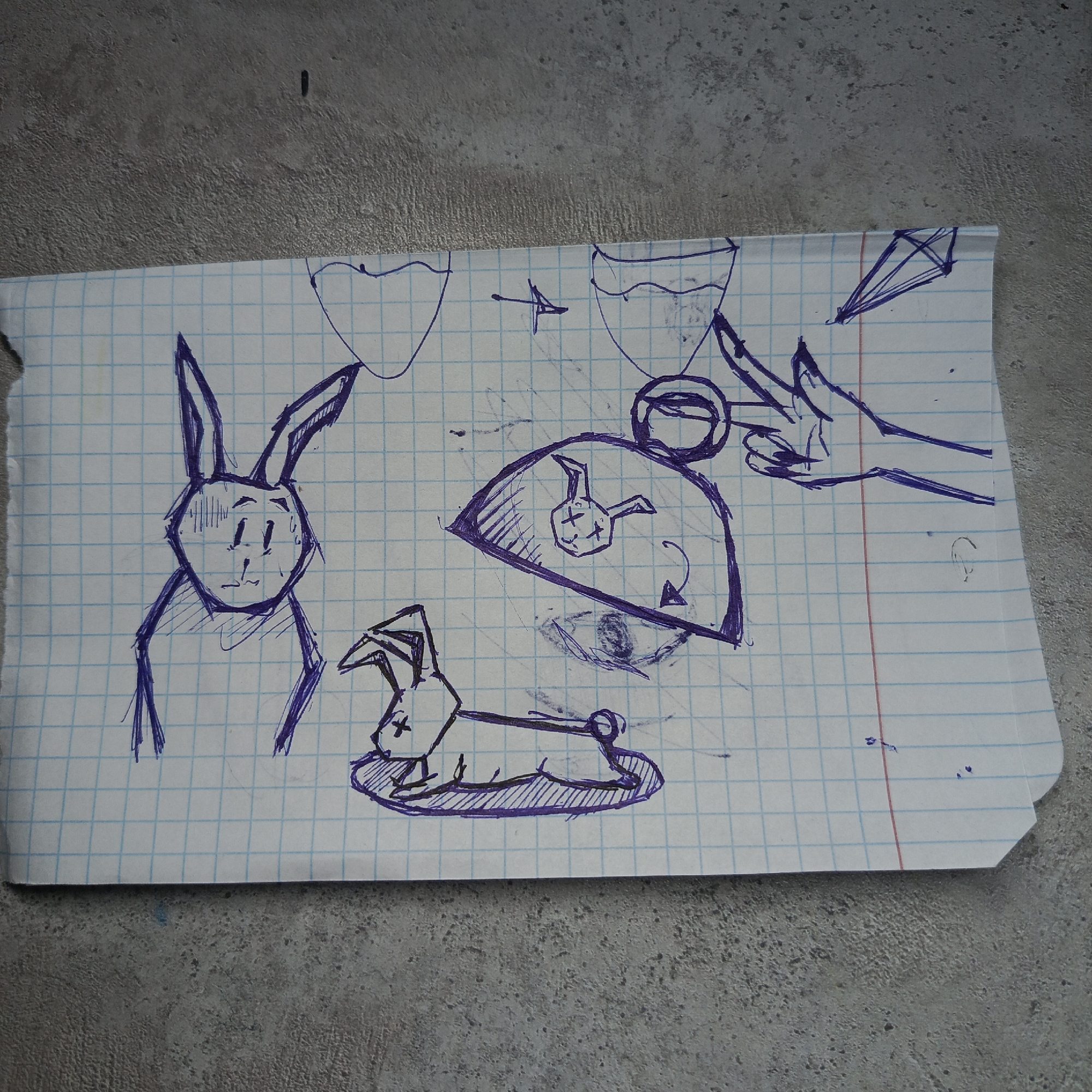 The image depicts a sheet of graph paper with various pen sketches in blue ink. There are two drawings of rabbits, one standing with a worried expression and the other lying down with "X" marks for eyes. Above these are two outlined shapes resembling hearts or vases. In the center, there is a partial image of a fan or dome with a smaller rabbit face with "X" marks for eyes drawn inside, along with a curved arrow. To the right, there is a drawing of a hand reaching towards a circle, and a diamond shape outlined above. The paper rests on a textured gray surface, possibly concrete.