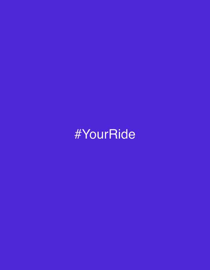 The image displays a solid, vibrant purple background, resembling a royal blue or deep violet hue. Centrally located on this monochromatic field is the white text, "#YourRide", rendered in a clear, sans-serif font.
There are no people, specific objects, or discernible scene elements present within the image beyond the uniform color and the text. The image itself provides no visual cues regarding any particular activity or event taking place, nor does it indicate a specific time of day, weather conditions, or any identifiable landmarks or features that would tie it to Barcelona, Spain, or any other location. It is a minimalist, graphic design, likely intended as a branding element or a social media hashtag. The overall impression is clean and direct, focusing solely on the textual message against a striking color.