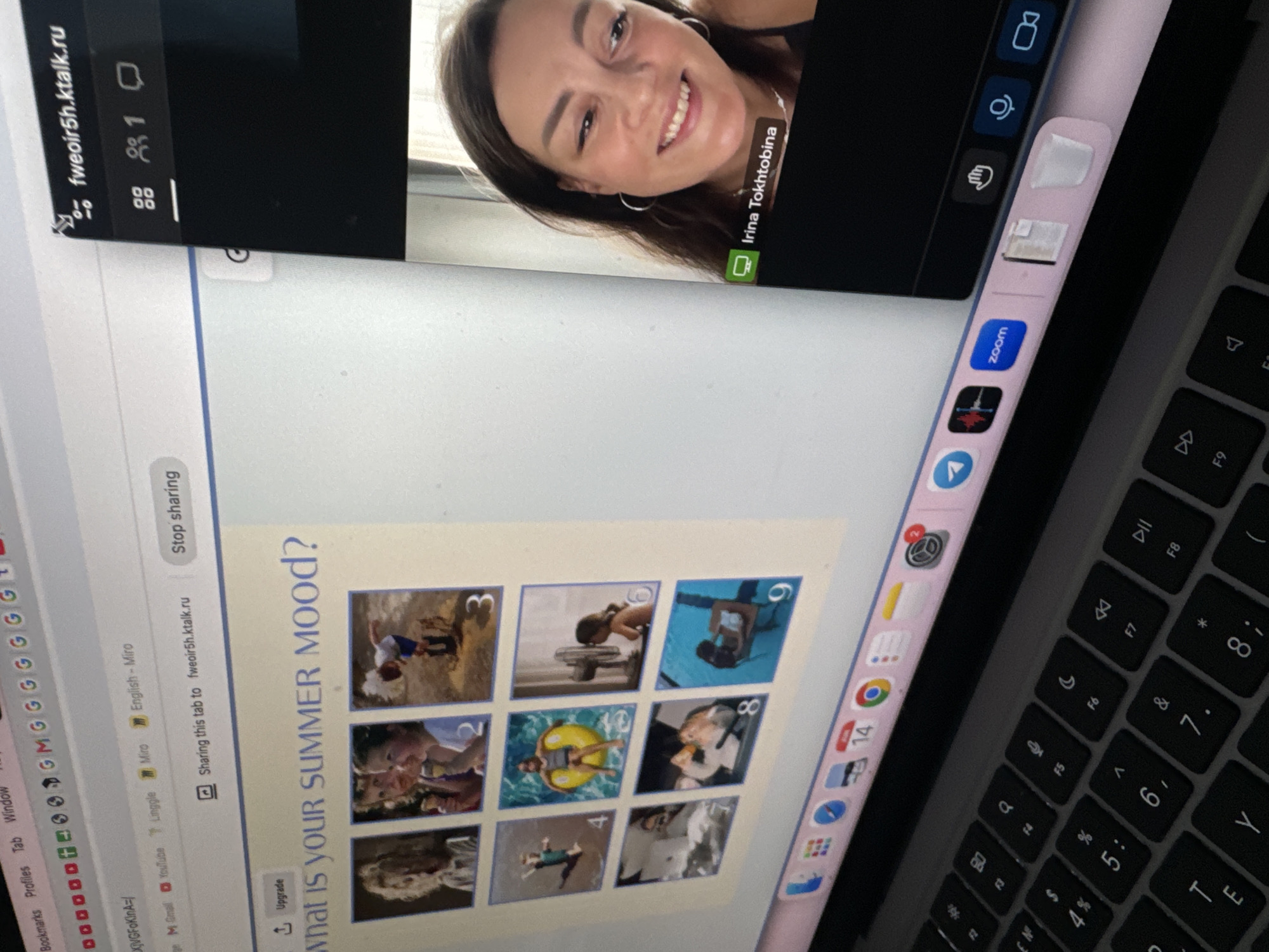 The image shows a screenshot of a video call on a laptop, with a woman named Irina Tokhtobina visible in the video feed. The laptop screen displays a webpage with the title "What is your summer mood?" and a grid of nine numbered images. The video call interface shows participant controls, including icons for screen sharing, participants, and chat. The laptop's keyboard and dock are also visible. The image does not contain any information that would allow for the determination of the location of the city of Krasnoyarsk, Russia.