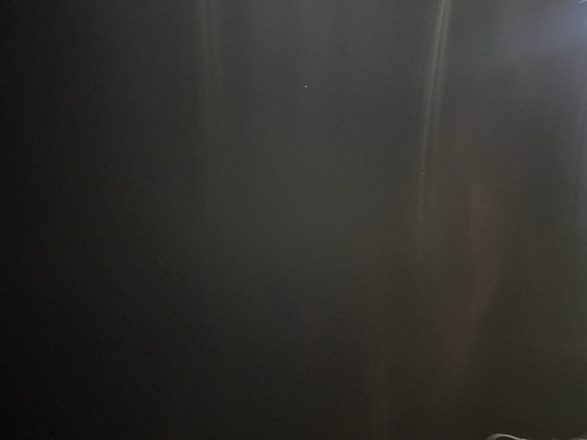 The image shows a dark, blurry, interior scene. It is difficult to make out details due to the poor lighting and lack of focus. There are some faint vertical streaks of light on the right side. There is no indication of location in Moscow, Russia or any other information regarding people, objects, actions, interactions, or the environment.