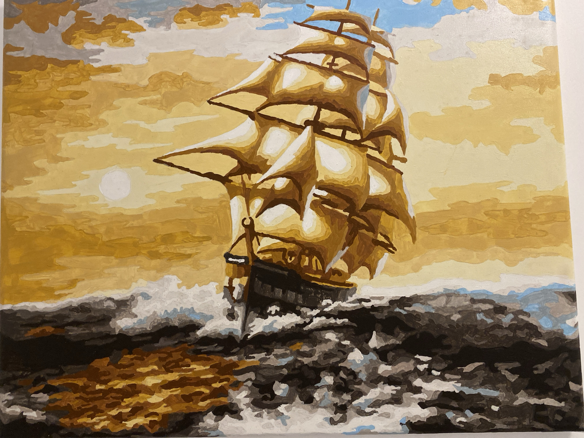 The image is a painting of a sailing ship on a stormy sea. The ship is dark, with tall masts and billowing sails, and is depicted in the foreground, cutting through choppy, dark waves. The sky is a dramatic blend of yellow and gray clouds, with hints of blue, suggesting a turbulent atmosphere, possibly at sunset or sunrise. A pale, circular sun or moon is visible in the upper left quadrant. The sea is rendered with thick brushstrokes, creating a sense of movement and spray. The overall impression is one of a powerful vessel braving the elements.
There is no indication that this image is located in Sozopol, Bulgaria.
