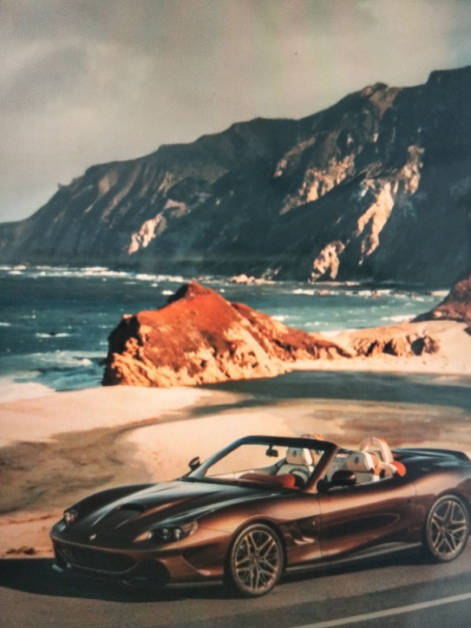 A convertible sports car with two passengers is parked on a road next to a beach with choppy water and rocky cliffs. The sky is overcast. The car is bronze in color with tan seats. The passengers are wearing white tops. The beach has tan sand and reddish-brown rocks. The ocean is a deep blue, and the cliffs are dark brown. The image does not depict any location in the city of Payagaboh, Indonesia.