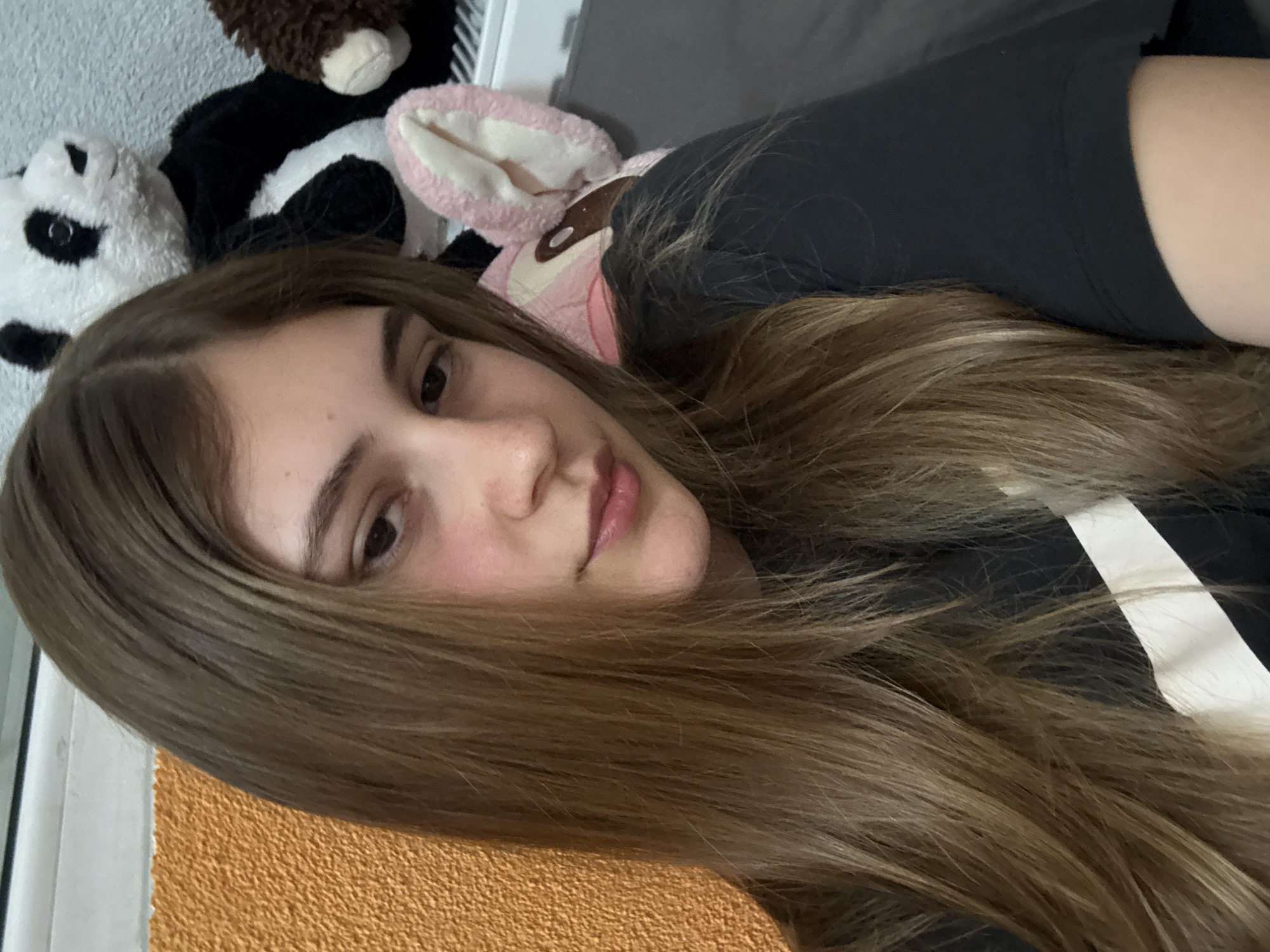 A woman is lying down next to stuffed animals. The location is not discernible from the image, and there is no evidence to suggest it is in Panagyurishte, Bulgaria.