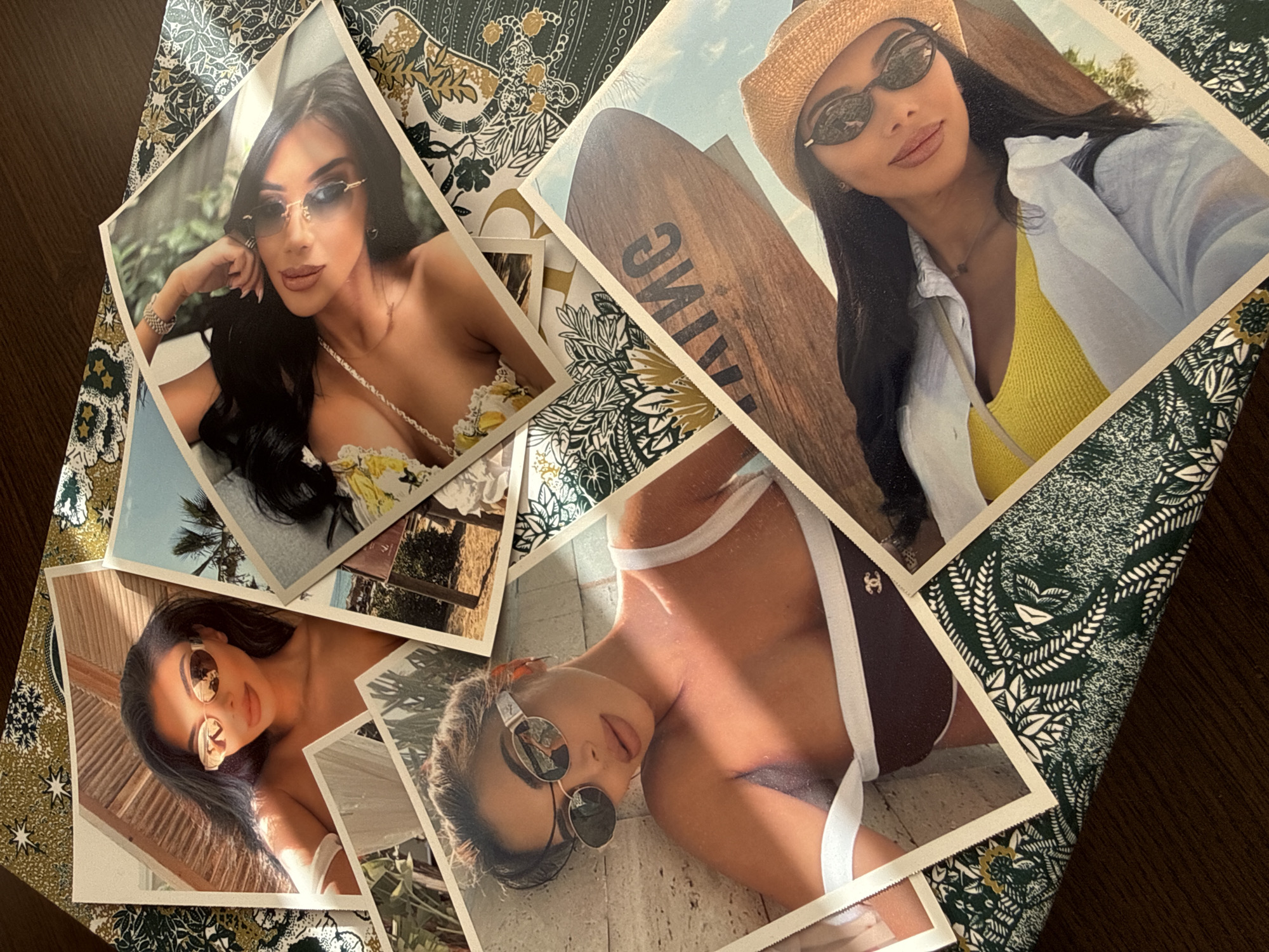 The image displays a collection of photographs scattered across a patterned surface, possibly a tablecloth or fabric. The photographs feature a young woman with dark hair, wearing sunglasses and swimwear. In some images, she is posed outdoors, with hints of sandy beaches and palm trees. In another, she is wearing a straw hat and a yellow top. The patterned surface beneath the photos is dark green with white and gold floral and star-like motifs. The overall impression is of a curated display of personal photos, possibly related to a vacation or a fashion shoot. There is no visible indication or any elements within the image that suggest a specific location in the city of Plovdiv, Bulgaria.