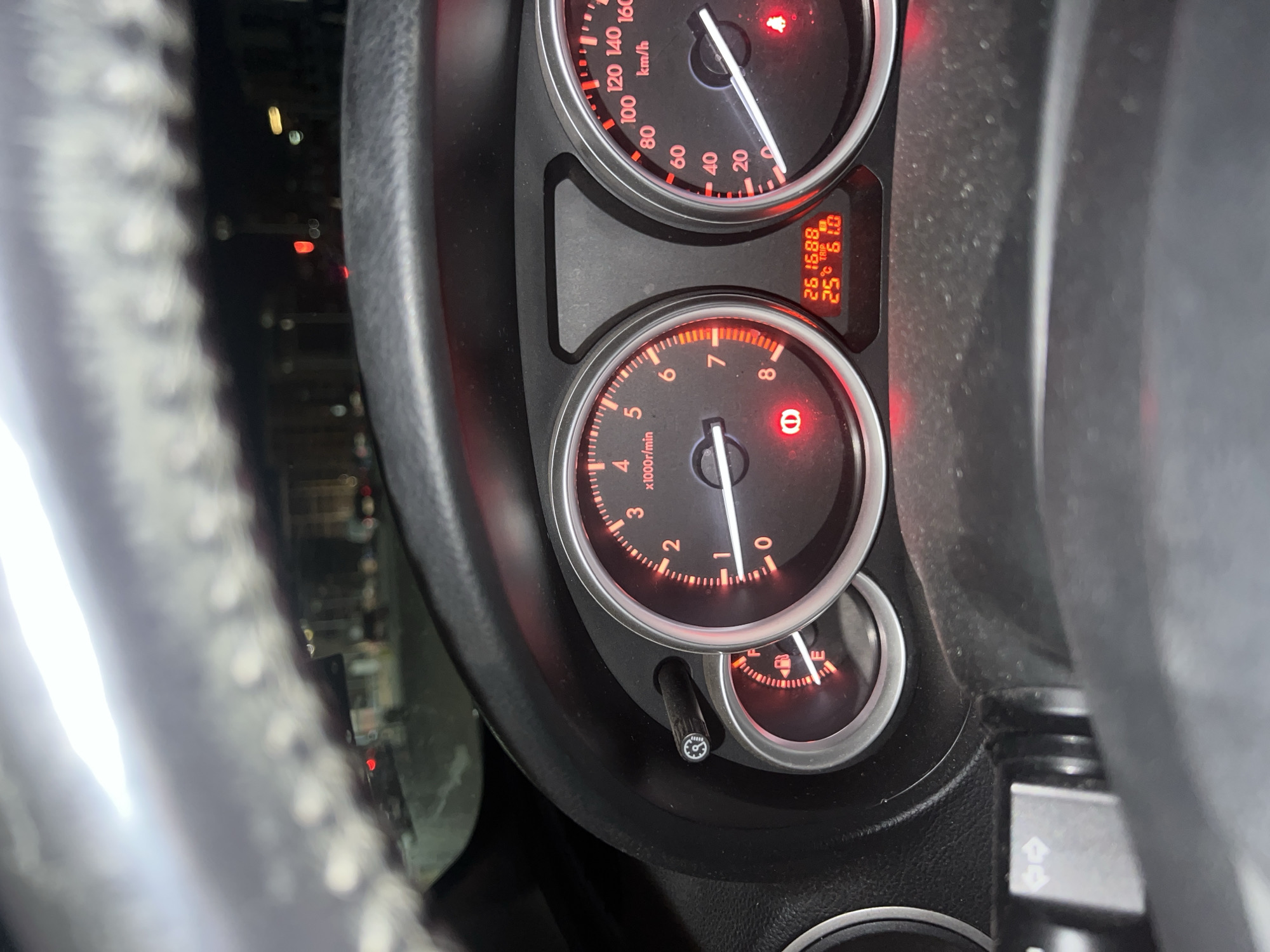 The image shows the dashboard of a car. The speedometer reads approximately 10 km/h. The tachometer shows the engine idling around 750 RPM. The fuel gauge indicates a low fuel level. The odometer displays 261,688 kilometers, and the trip meter reads 61.0 kilometers. The outside temperature is 25 degrees Celsius. The exact location in Burgas, Bulgaria cannot be ascertained from the image alone. The presence of a steering wheel suggests the image was taken from the driver's perspective.