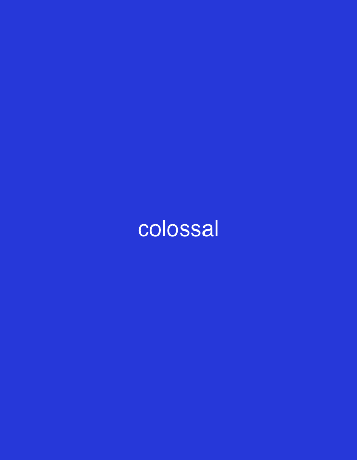 The image displays a plain, royal blue background with no discernible subjects, objects, or specific scene details. There is no activity or event taking place. The sole visible element is the word "colossal" written in white, lowercase letters, centered on the blue field. There are no other notable details such as time of day, weather, or location cues within the image itself. The context for this media file is Santa Ana, Venezuela.
