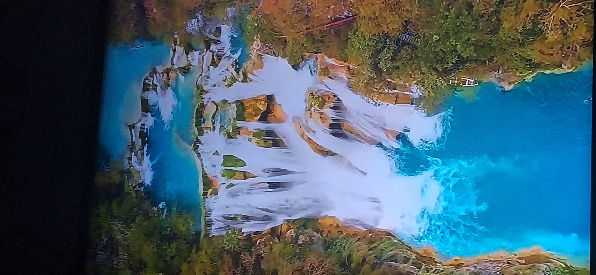 The image depicts a multi-tiered waterfall with turquoise pools of water cascading down rocky formations. Lush green vegetation surrounds the falls. The scene is serene and natural, with no visible people or man-made structures immediately apparent in the main waterfall area. The question of its location in Bila Tserkva, Ukraine, is not supported by visual evidence in the image.
