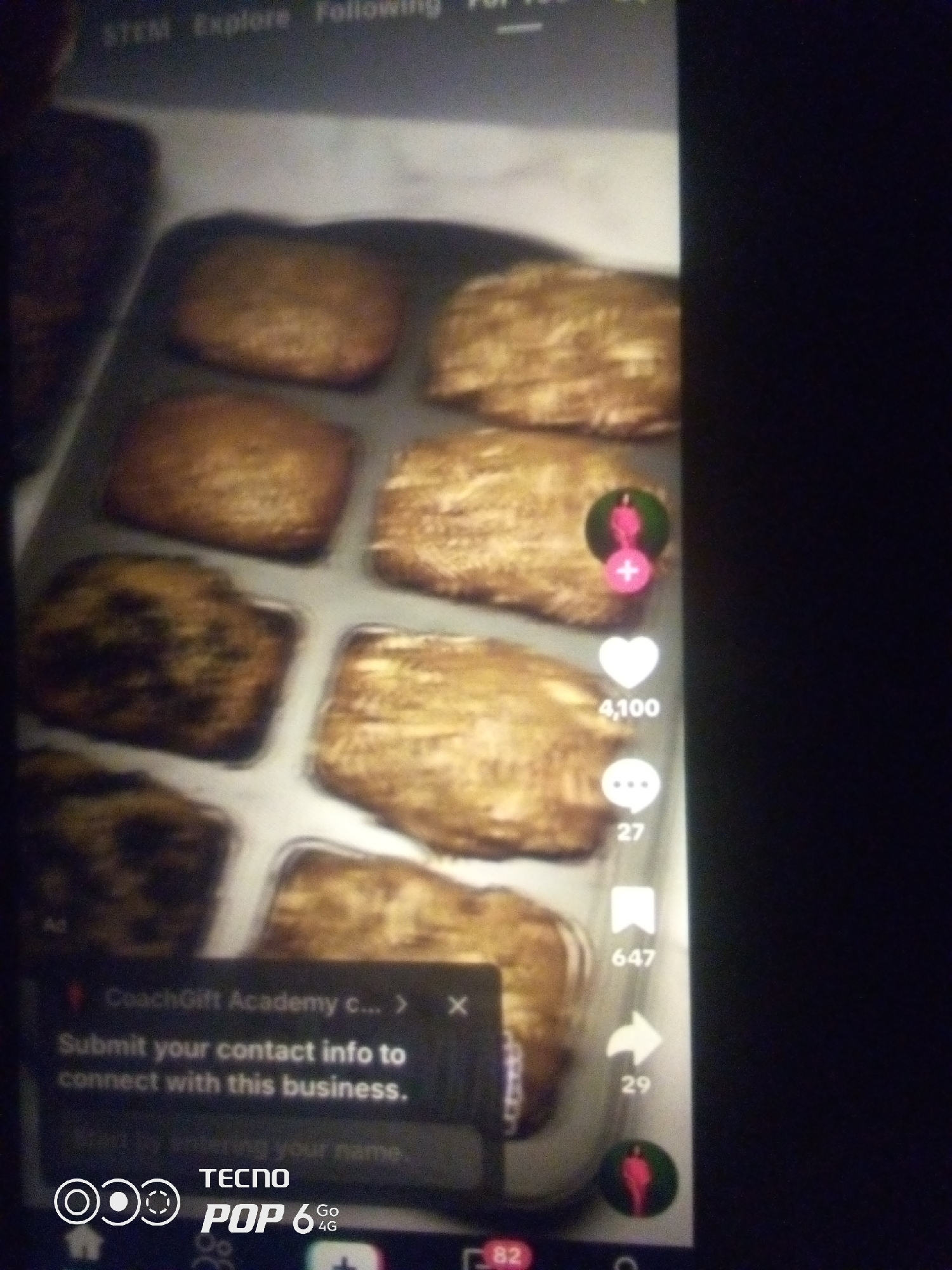 The image shows a baking tray filled with golden-brown, rectangular pastries. These pastries appear to be arranged in a grid-like fashion within the tray. On the right side of the image, there are several interactive icons commonly found on social media platforms, indicating likes, comments, shares, and user profiles. There is also a pop-up message overlaying the pastries that reads, "Submit your contact info to connect with this business." Below this, partially obscured, are the words "TECNO POP 6 GO 4G", suggesting the image was captured or displayed on a Tecno Pop 6 Go mobile phone. The top of the screen displays navigation options like "STEM," "Explore," and "Following." The background is dark and out of focus. There is no discernible information within the image that places it in Howayi, Nigeria, or any specific city.