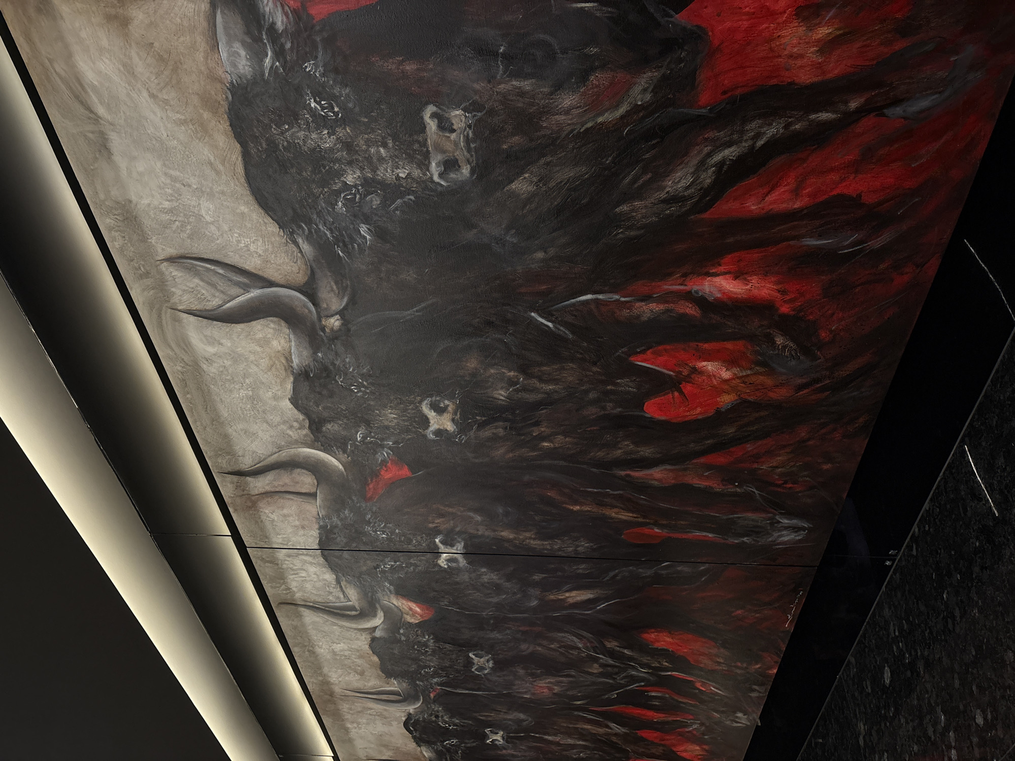 A painting depicting bulls, with a palette of red, black, and grey, is visible on a wall. The setting is suggested as being in San Bernardino Tlaxcalancingo, Mexico.
