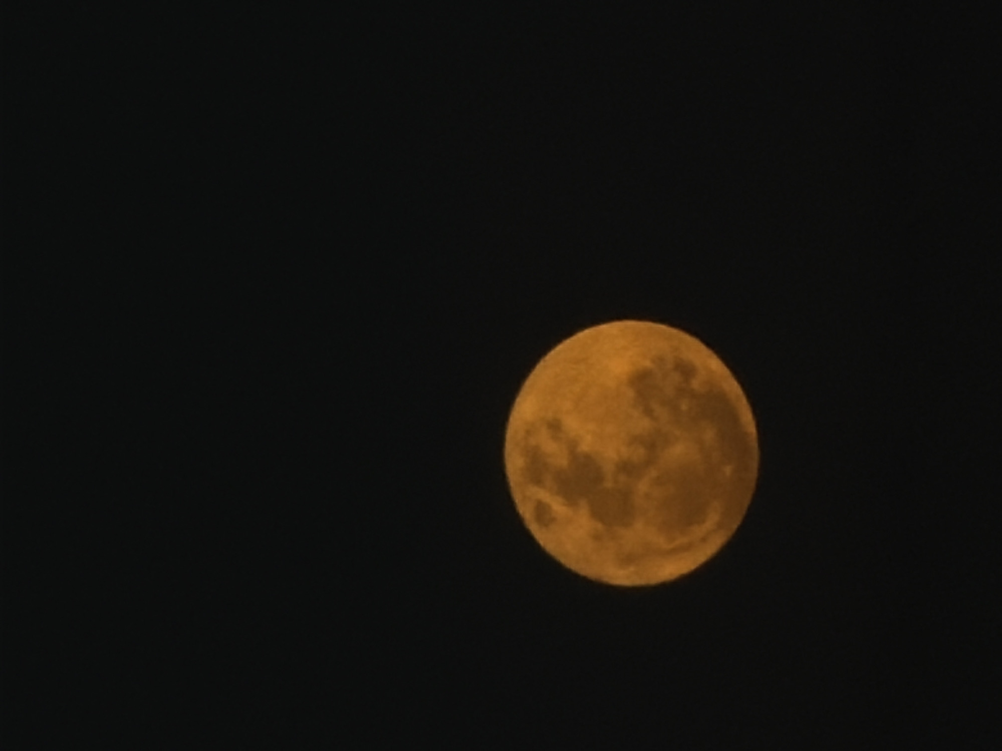 The image shows a full moon in the night sky. The moon is located in the upper right of the frame. The surrounding sky is dark. The image was likely taken outdoors. The location in the city of Mengwi, Indonesia is unverifiable from the image.