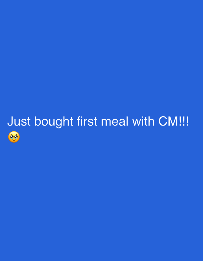 The image displays white text on a solid royal blue background. The text reads, "Just bought first meal with CM!!!", followed by an emoji depicting a face with wide, innocent eyes and rosy cheeks, suggesting feelings of excitement, adoration, or shyness. There are no other discernible subjects, objects, or specific scene details within the image itself. The activity described is the purchasing of a "first meal" with an individual or entity referred to as "CM". While the image lacks visual cues for location, this event occurred in Paris, France, as per the provided context.