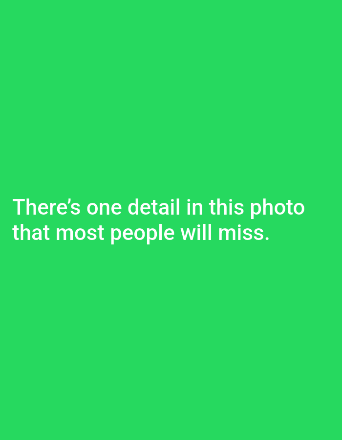 The image is a solid bright green background. White text is overlaid on the image, centered horizontally and in the lower half of the frame. The text reads: "There's one detail in this photo that most people will miss." There are no people, subjects, objects, or actions depicted in the image. There is no information present that can be used to determine the location in the city of Pagerungan Kecil, Indonesia.