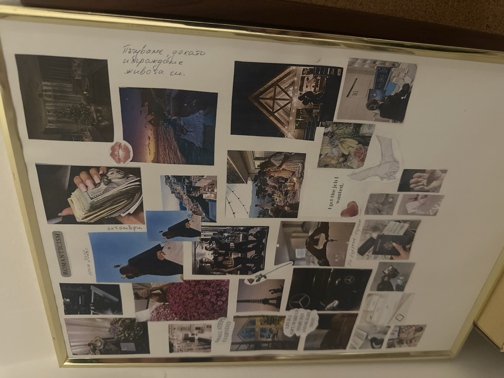 The image shows a framed collage. The collage contains various printed images, including landscapes, architectural structures, money, people, and motivational phrases. Some phrases include "ROMANTICISM," "October," "Small steps everyday," and "Life is a gift. Wake up every day and realize that." One picture has the date "June 2026." There's also a handwritten message in Cyrillic. A passport is present in one of the images. The location of the scene in Sofia, Bulgaria, cannot be determined solely from the image.