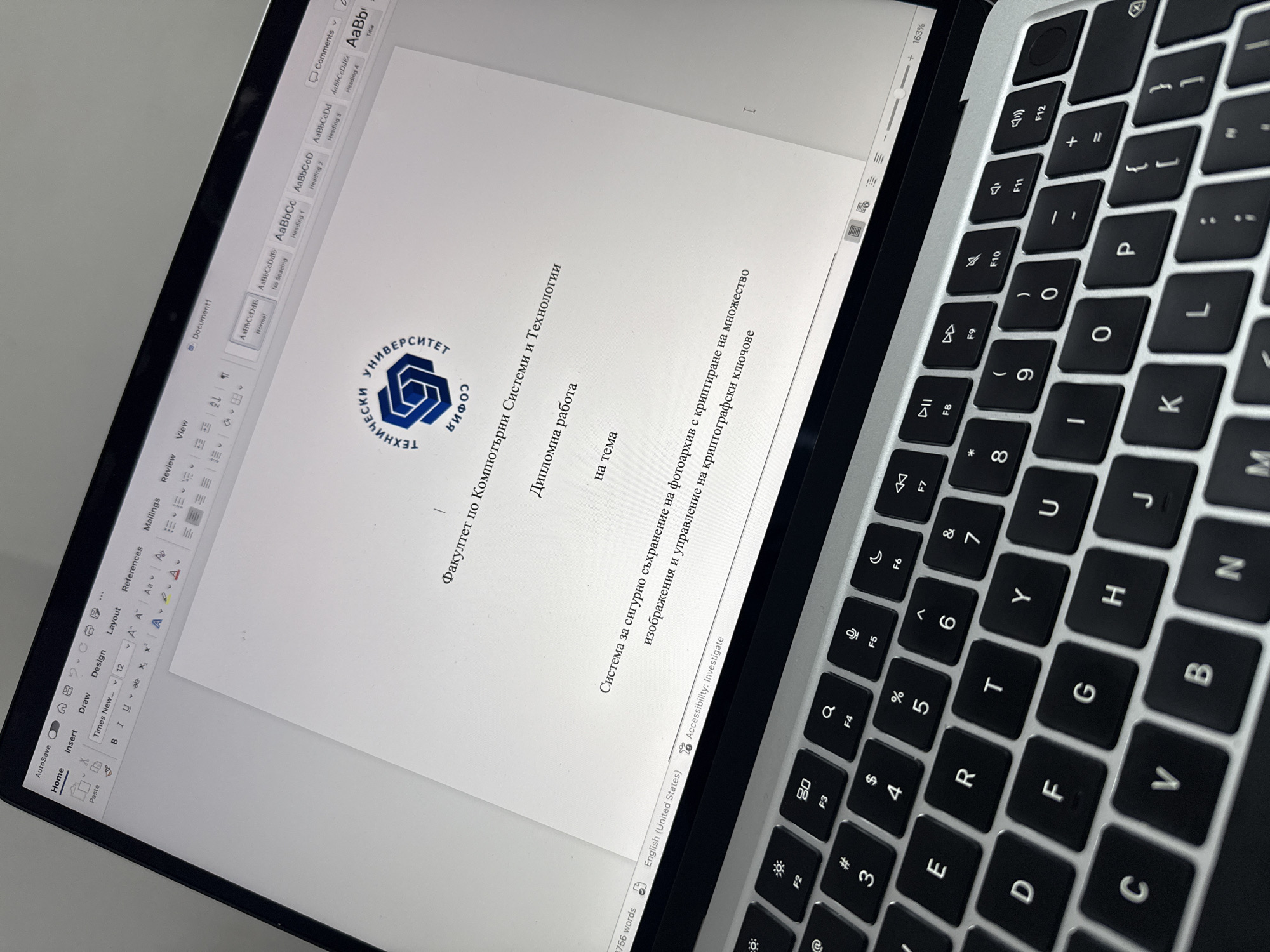 The image shows a laptop screen displaying a Microsoft Word document. The document appears to be a diploma thesis, as indicated by the heading "Дипломна работа" (Diploma Work) and the text "Факултет по Компютърни Системи и Технологии" (Faculty of Computer Systems and Technologies). The logo of the Technical University of Sofia is visible at the top, suggesting that the location is within the city of Sofia, Bulgaria. The title of the thesis is something along the lines of "System for secure storage of photo archives with encryption on multiple images and management of cryptographic keys." The laptop keyboard is visible to the right of the screen. The screen also shows the Microsoft Word interface, including tabs like "Home," "Insert," "Draw," "Design," "Layout," "References," "Mailings," "Review," and "View." The status bar at the bottom indicates that the document contains 2756 words and is set to English (United States). The zoom level is set to 163%.