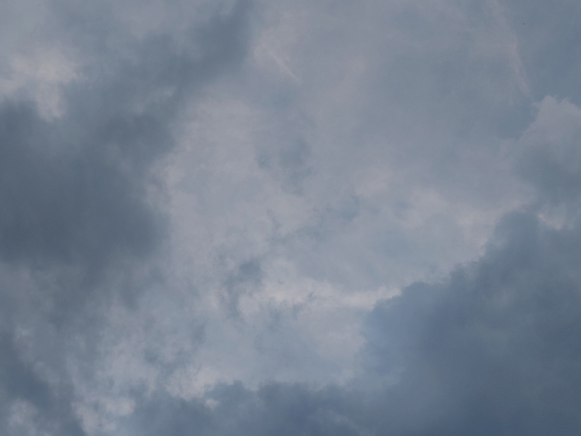 The image displays a close-up view of an overcast sky, characterized by dark, heavy clouds. The lighting is dim, suggesting an impending storm or a generally gloomy weather condition. There are no visible subjects, objects, actions, or interactions. The environment is solely composed of the cloud formations. The location is identified as Podstyopnovka, Russia, but this context does not alter the visual description of the image itself.