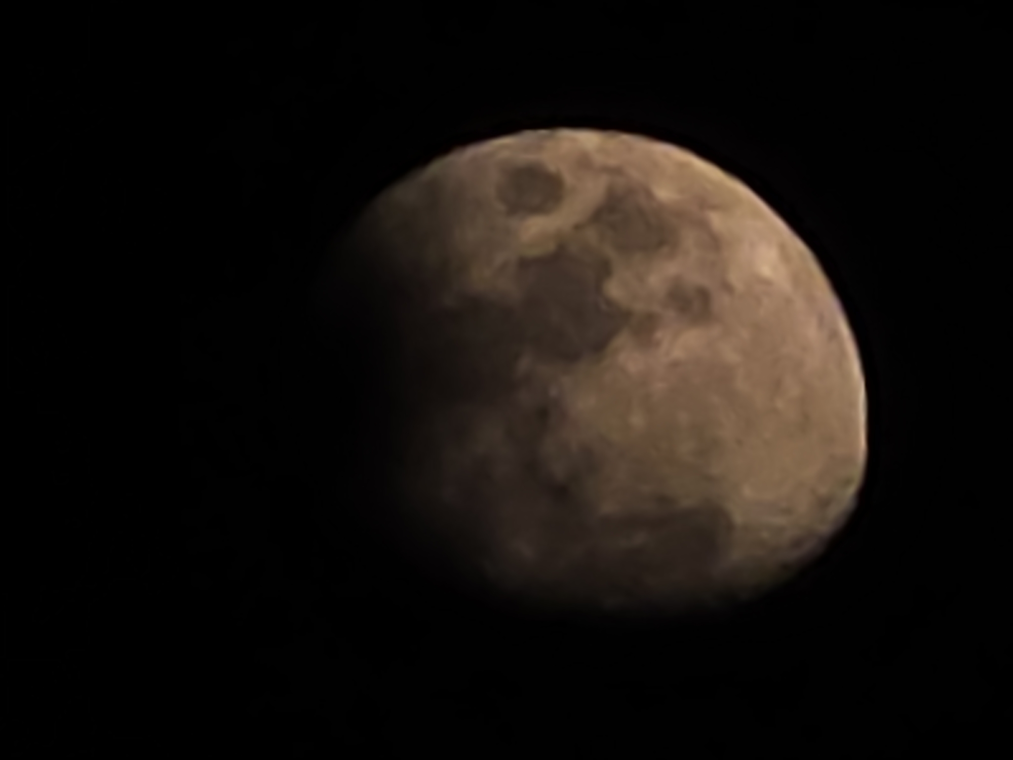 A close-up shot reveals a waning gibbous moon against a black sky. The moon's surface shows craters and variations in shading. The location is unknown; there is no indication of Warsaw, Poland, in the image.