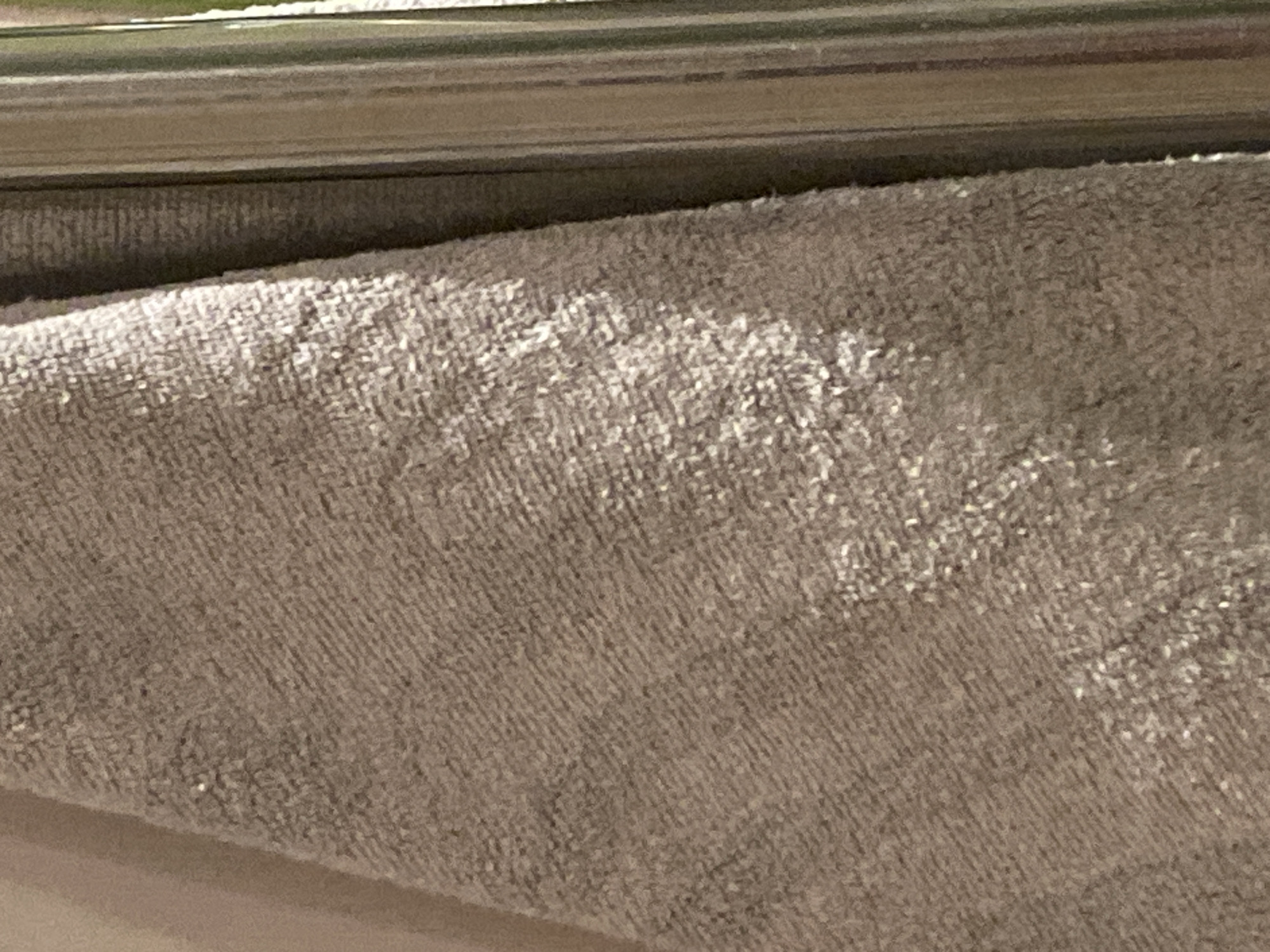 The image shows a close-up of a grey towel hanging on a metallic towel bar. The towel's texture is clearly visible, with variations in light reflecting off the fibers. The towel bar is smooth and cylindrical. No people or other objects are visible. The location in Sofia, Bulgaria, is not discernible from the image.