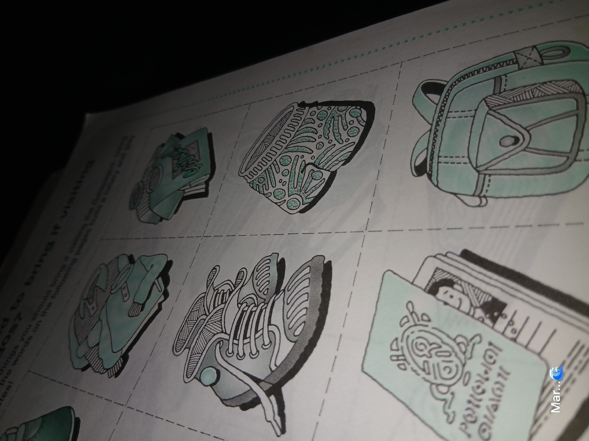 The image displays a portion of a page from a workbook or activity book, likely intended for children, with various illustrated objects. The items are outlined in black and filled with a light teal color, creating a stylized, somewhat playful aesthetic. The objects appear to be cutouts or drawings meant to be used in an activity.
In the upper section of the image, a partial view of a pair of teal-colored shoes or boots is visible on the left. To the right of these, in the same row, is a drawing of a teal t-shirt. Below this, on the left, is a detailed drawing of a pair of teal and white sneakers, with laces and textured soles. To the right of the sneakers, in the middle row, is a drawing of teal-colored shorts with a patterned design.
In the bottom left of the image, a passport or booklet is shown, with a teal cover featuring a stylized emblem or logo in the same teal color. Text in a blocky, stylized font appears on the cover, reading "POLLOGIA/OLLONAI". A small, cartoon-like illustration of a person's face is visible within the booklet. Below this booklet, the word "Mar..." is written, followed by a blue wave emoji.
In the bottom right, a teal backpack is depicted, with a flap pocket on the front and straps. The entire page is printed on white paper and appears to be from a printed publication. The lighting in the image is dim, with a strong diagonal shadow across the right side of the frame, obscuring parts of the page.
The image does not contain any information or visual cues related to the city of La Tagua, Venezuela.