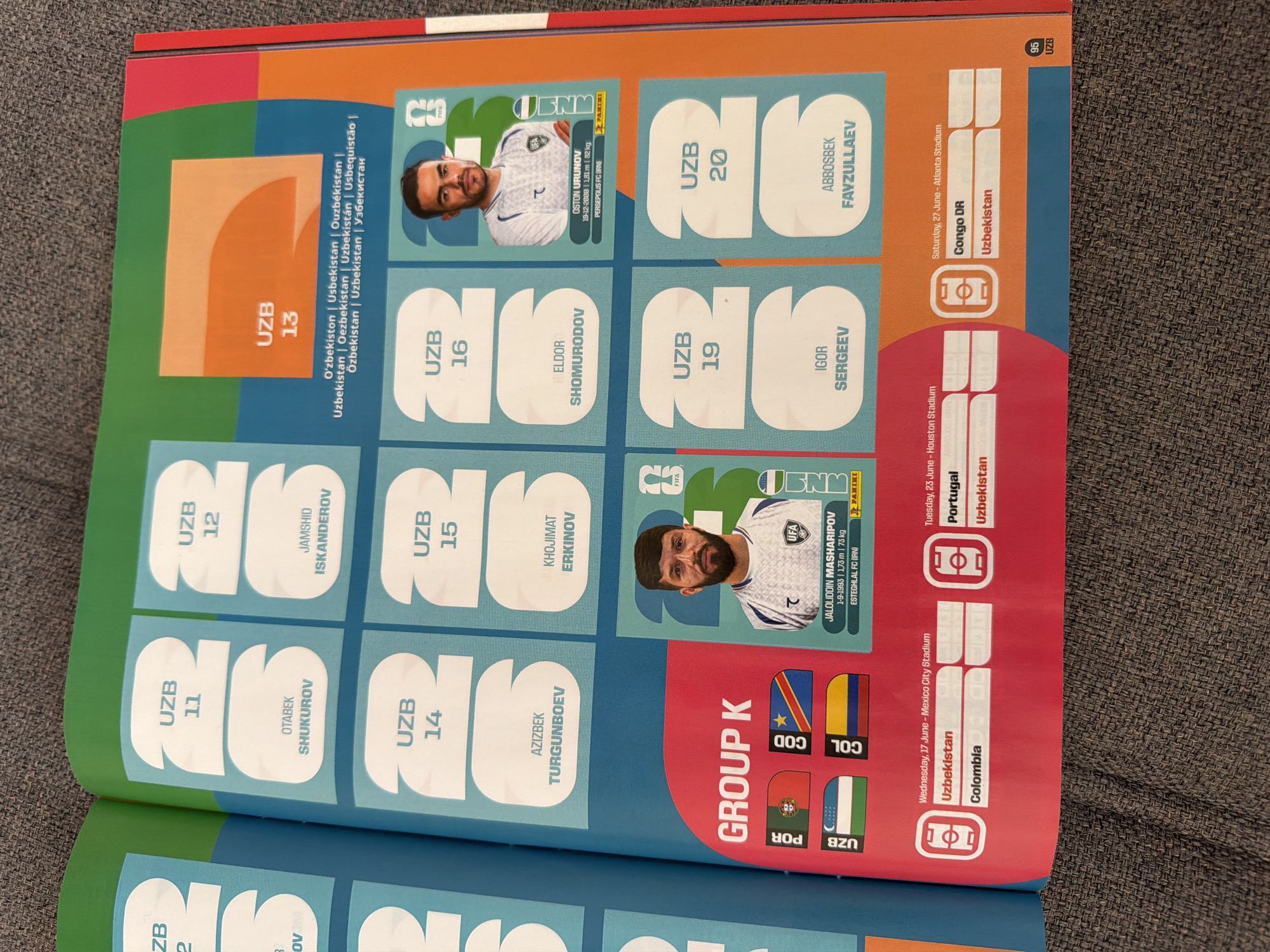 The image shows a two-page spread from a sticker album, likely related to a football (soccer) tournament. The left page displays several player stickers for Uzbekistan (UZB), with numbers 11, 12, 14, and 15 visible. Each sticker has a placeholder for a player's image and their name below. Some names visible are Otabek Shukurov, Jamshid Iskanderov, Azizbek Turgunboev, and Khojimat Erkinov. The bottom left of the left page has a section labeled "GROUP K" with flags of Portugal (POR), Congo DR (COD), Uzbekistan (UZB), and Colombia (COL). Below this, a schedule of matches is displayed, with dates, locations (Mexico City Stadium, Houston Stadium, Atlanta Stadium), and participating teams. The right page features more player stickers for Uzbekistan, with numbers 13, 16, 19, and 20 visible. Some names visible are Eldor Shomurodov, Igor Sergeev, and Abbosbek Favzullaev. A sticker with player Oston Urunov is also shown, with his details and club. The overall aesthetic is colorful and organized, typical of sports memorabilia. There are no people, subjects, objects, actions, or interactions that place the scene in Zlatitrap, Bulgaria.